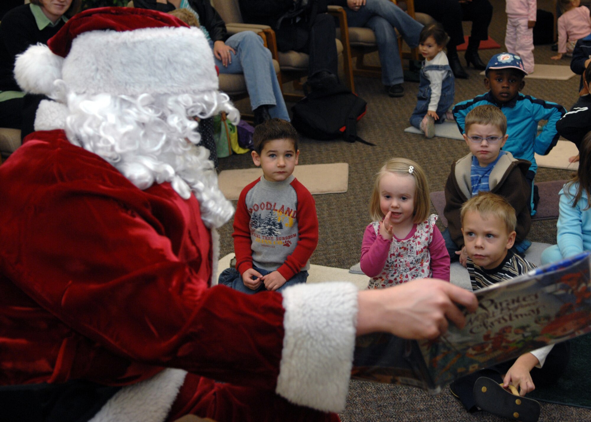 1st Lt. Joseph Dowell, 49th Mission Support Group, plays Santa for his story time reading of “The Pirate's Night Before Christmas” at Ahren's Memorial library at Holloman Air Force Base, N.M., Dec. 17. Children of Holloman sat around Santa as they listened closely to the story. (U.S. Air Force photo/Airman 1st Class Veronica Salgado)