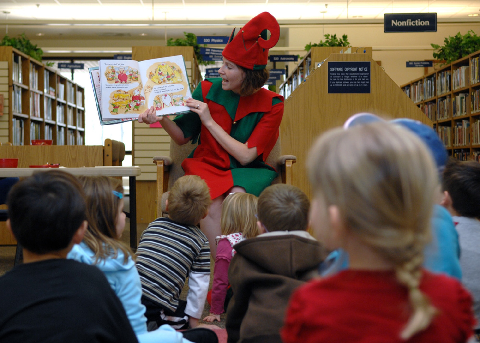 Janelle Hockman, dressed as Santa's helper, reads “Who'll Pull Santa's Sleigh Tonight” at Ahren's Memorial library at Holloman Air Force Base, N.M., Dec.17. Children read along as they patiently wait for Santa's arrival. (U.S. Air Force photo/Airman 1st Class Veronica Salgado)