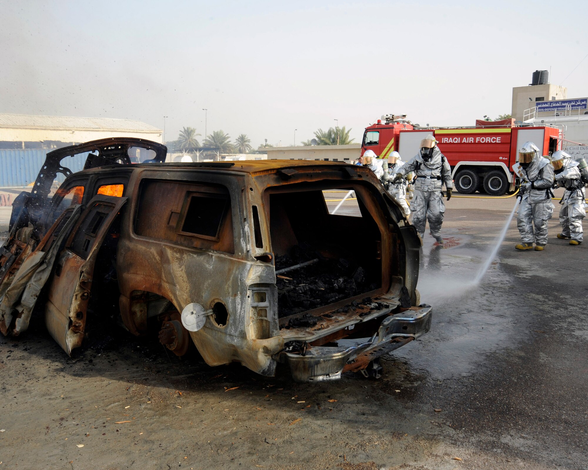 Master Sgt. James Brody, center, observes Iraqi firefighters as they extinguish a fire during a training exercise in Baghdad, Iraq, Dec. 24. Sergeant Brody is an assistant firefighter instructor and is deployed to the 447th Expeditionary Civil Engineer Squadron, at Sather Air Base, Iraq, where he is the training chief. (U.S. Air Force photo/Staff Sgt. Paul Villanueva II)