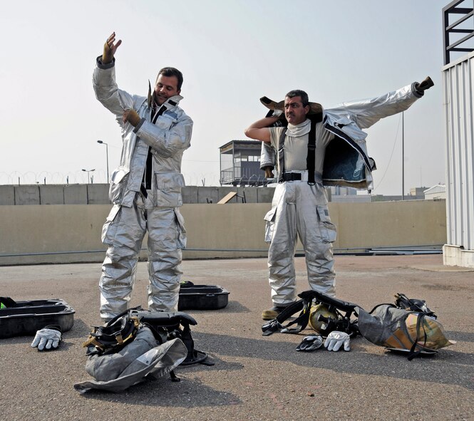 Iraqi firefighters don their personal protective equipment before participating in a live fire exercise in Baghdad, Iraq, Dec. 24. The firefighters are part of a 60-day firefighter apprentice course. (U.S. Air Force photo/Staff Sgt. Paul Villanueva II)