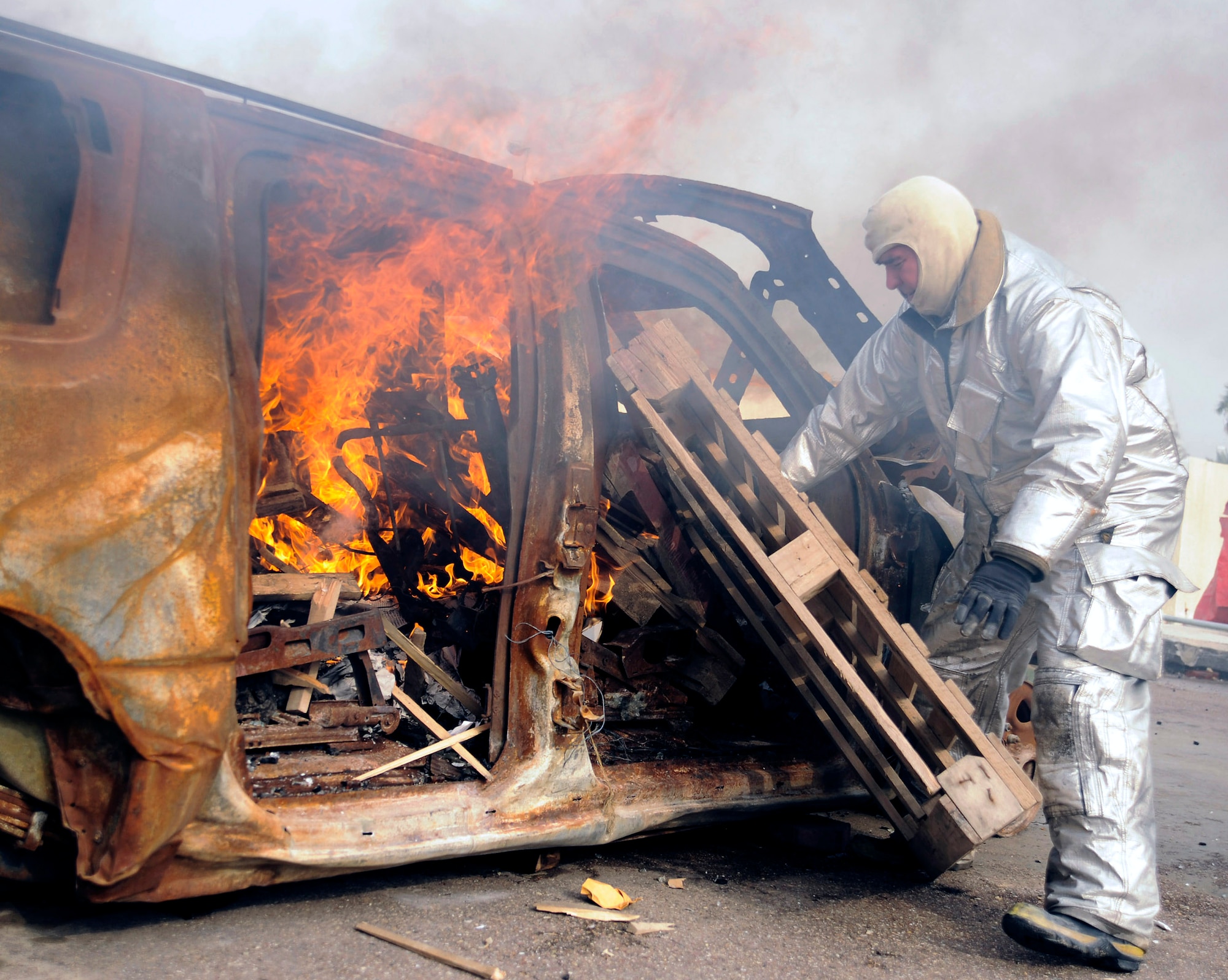 Master Sgt. James Brody creates a simulated car fire for a live burn exercise in Baghdad, Iraq, Dec. 24. Sergeant Brody is an assistant firefighter instructor, and is deployed from the 174th Fighter Wing, Syracuse Air National Guard, N.Y. (U.S. Air Force photo/Staff Sgt. Paul Villanueva II)