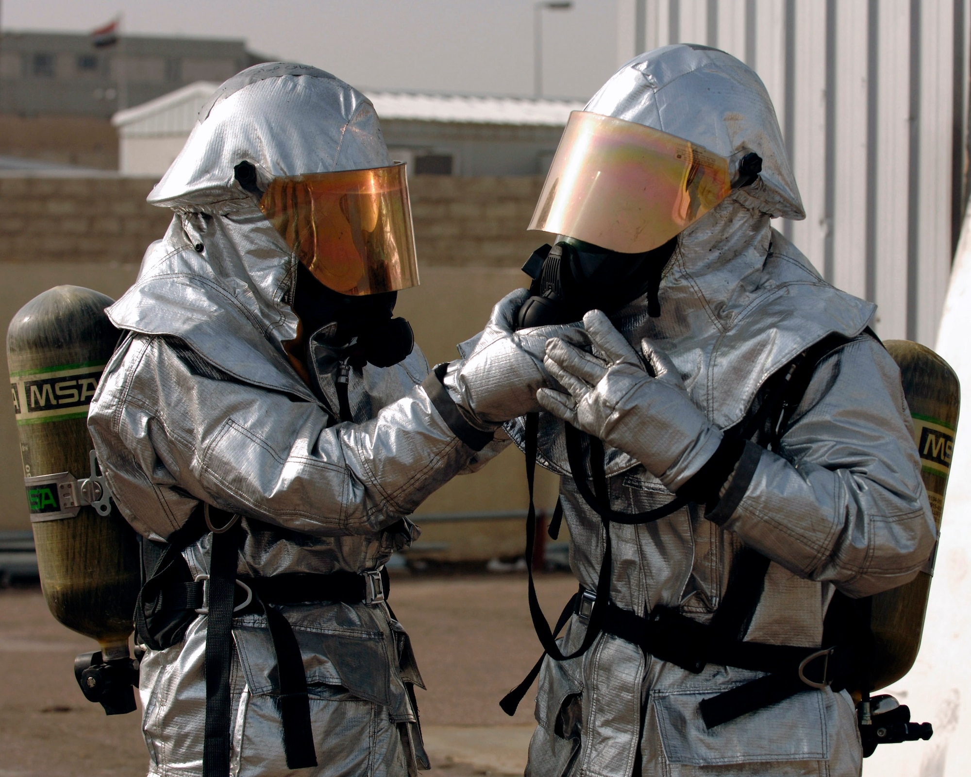 An Iraqi firefighter double checks his partner's personal protective equipment before participating in a live fire training scenario in Baghdad, Iraq, Dec. 24. The firefighters are taking the firefighter apprentice course being taught by members of the U.S. Air Force. (U.S. Air Force photo/Staff Sgt. Paul Villanueva II) 
