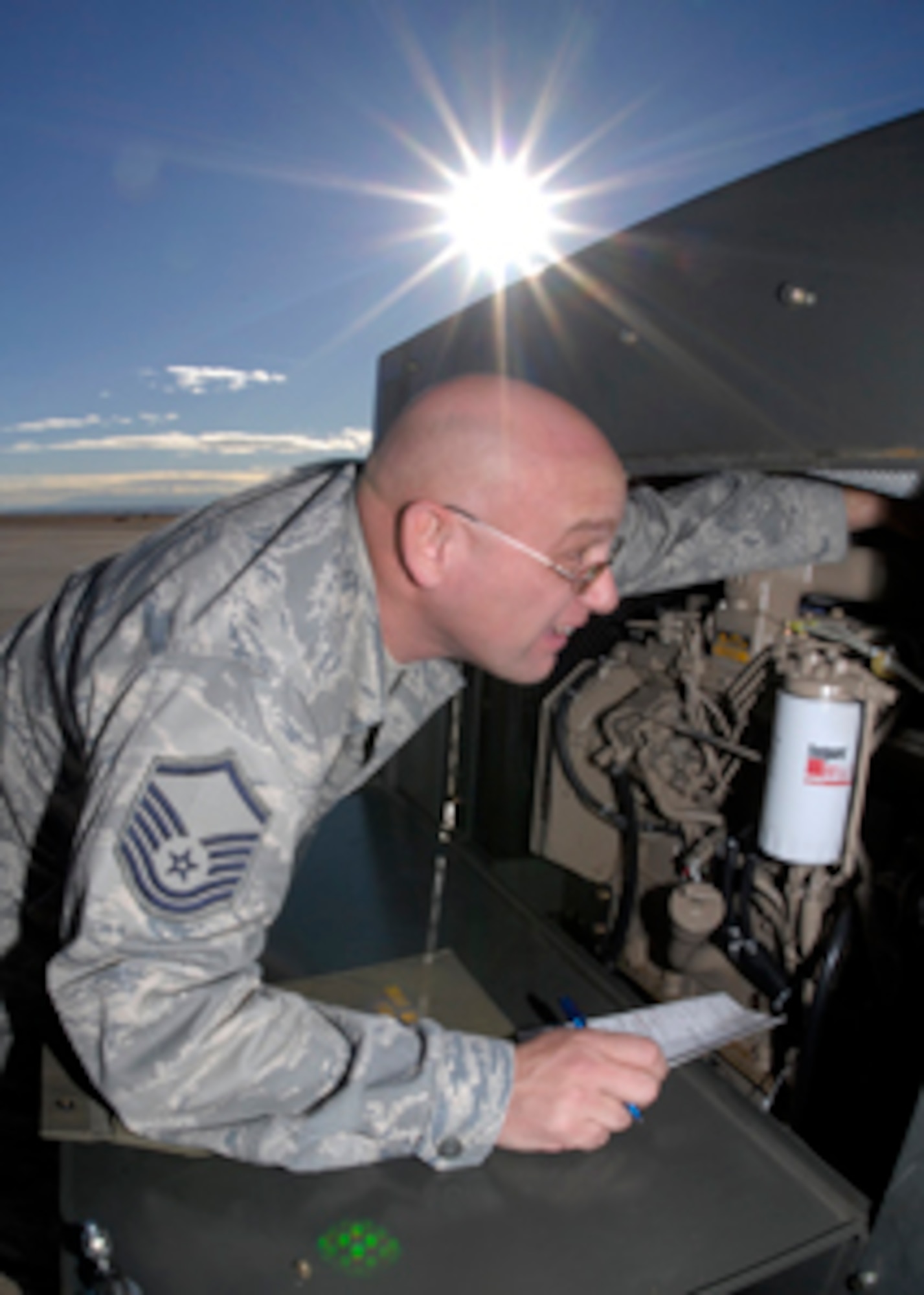 In the cold December afternoon sun, Master Sgt. Lonnie L. Gann of 21OSS/MA is performing a daily inspection on a diesel generator in support of a C-130 aircraft. One of many duties required by his unit, inspections of ground support equipment is an important part of his day. (Air Force photo/Rob L. Bussard) 