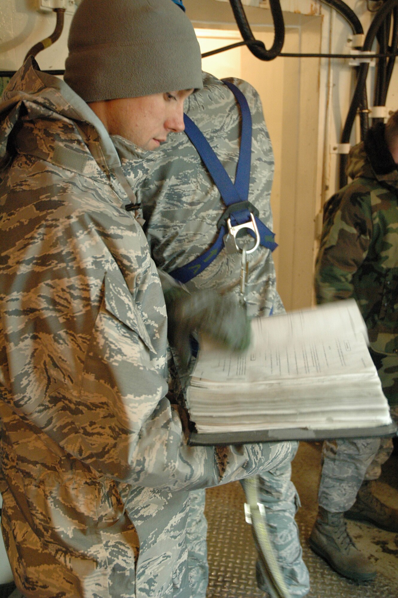 Staff Sgt. Nate Greene, 341st Maintenance Operations Squadron Team Training Section student, refers to technical orders to direct his missile maintenance team in the procedures necessary to "safe" an inert Minuteman III at the T-9 trainer Dec. 16. Sergeant Greene has more than two years of experience as a missile maintenance team member and his current training will prepare him to lead a MMT in the missile complex. (U.S. Air Force photo/Senior Airman Dillon White)