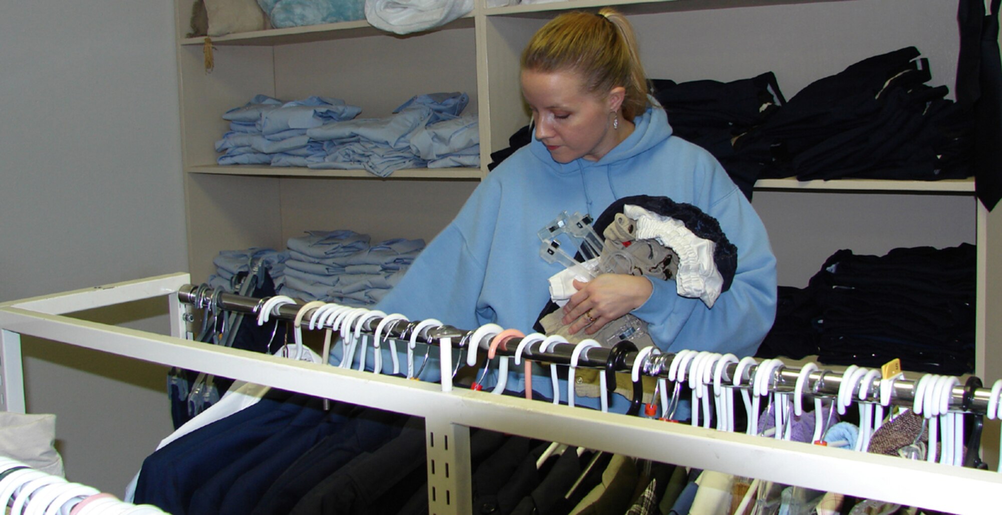 Leah Andrews, volunteer, hangs and sorts clothing at the Airman's Attic. The Airman's Attic is located in building 4000 and is open Thursdays and Saturdays from 10 a.m. to 2 p.m. E-5 and below can come to the Airman's Attic and take or borrow items for free. (U.S. Air Force photo/Senior Airman Emerald Ralston)     