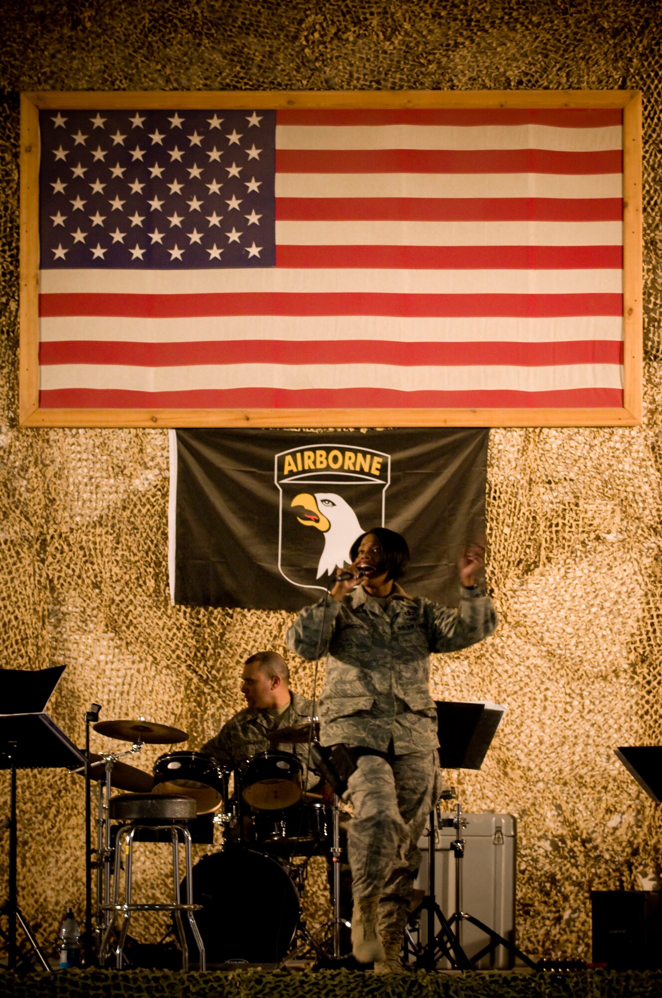 Air Forces Central band "Mojave" plays their feature performance at Bagram Air Field, Afghanistan, Dec. 27. The Army's 101st Airborne Division flag hangs proudly below the American Flag on the stage, but branch of service -- or nationality -- did not matter during this performance. Soldiers, sailors, Marines and Airmen of all nationalities came out to enjoy the music. (U.S. Air Force photo by Staff Sgt. Samuel Morse)(Released)