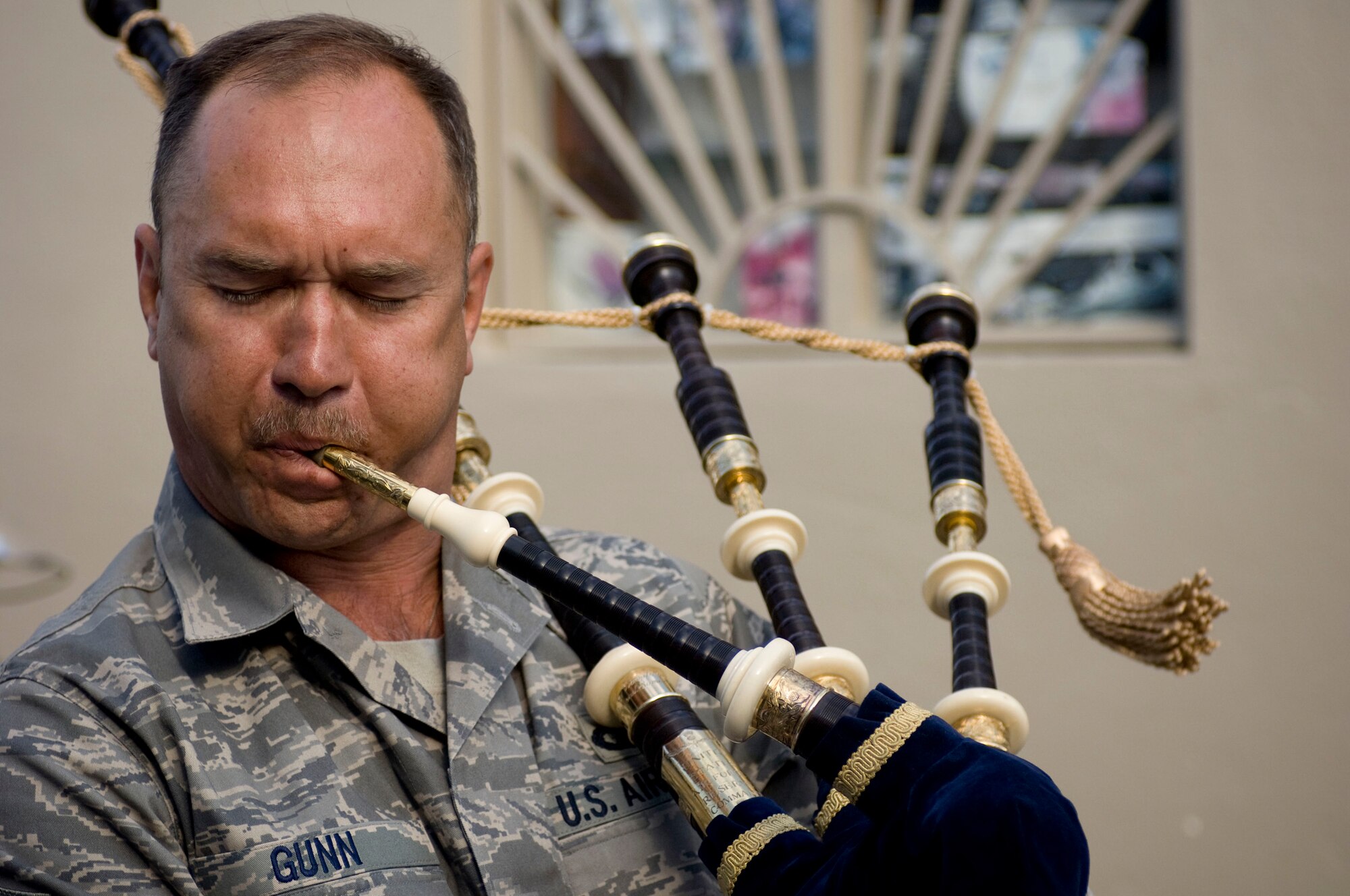 Master Sgt. Scott Gunn, piper and guitar player for U.S. Air Forces Central band "Mojave," plays the bag pipes at the PX complex at Bagram Air Field, Afghanistan, Dec. 27. The oboe player, turned piper, turned guitar player picked up his favorite instrument during one song to give the audience something they haven't likely heard before -- rock music featuring bag pipes. Sergeant Gunn is from Toledo, Ohio. (U.S. Air Force photo by Staff Sgt. Samuel Morse)(Released)