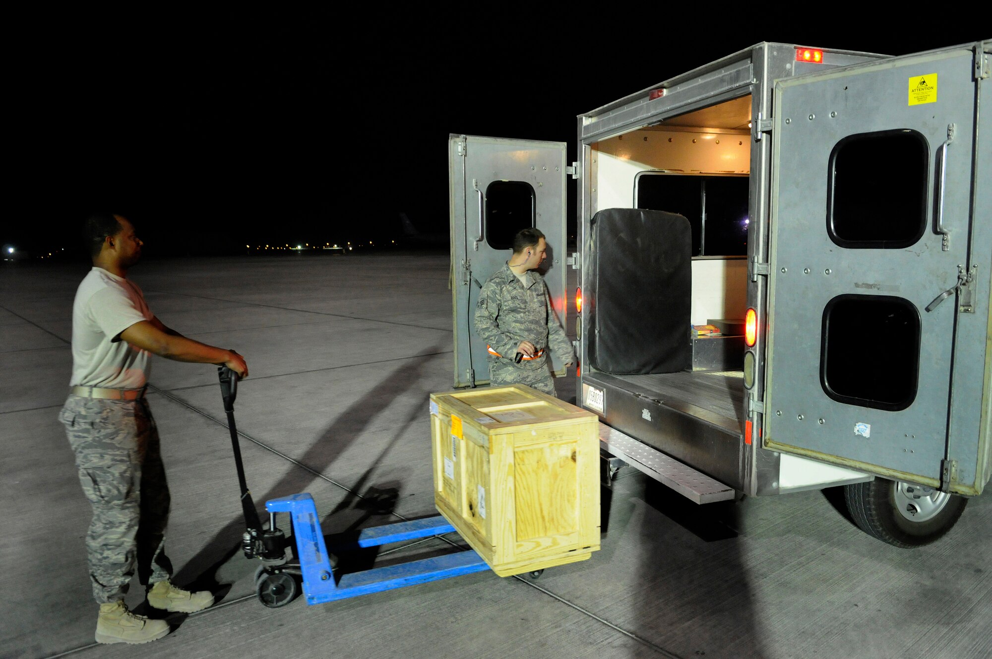 Staff Sgt. Daniel Harrington, a supply journeyman assigned to the 379th Expeditionary Logistics Readiness Squadron, delivers an aircraft part on the flightline to Senior Airman Adam Hall, an aircraft maintenance journeyman assigned to the 379th Expeditionary Aircraft Maintenance Squadron, from the consolidated aircraft parts storage warehouse, Dec. 28, at an undisclosed air base in Southwest Asia.  The supply team runs the CAPS facility, a collocated facility where all maintenance teams can go to pick up items needed to fix their specific aircraft.  Sergeant Harrington, a native of Atlanta, Ga., is deployed from MacDill Air Force Base, Fla.  Airman Hall hails from Nashville, Tenn.  Both are supporting Operations Iraqi and Enduring Freedom and Joint Task Force-Horn of Africa.  (U.S. Air Force photo by Tech. Sgt. Michael Boquette/Released)