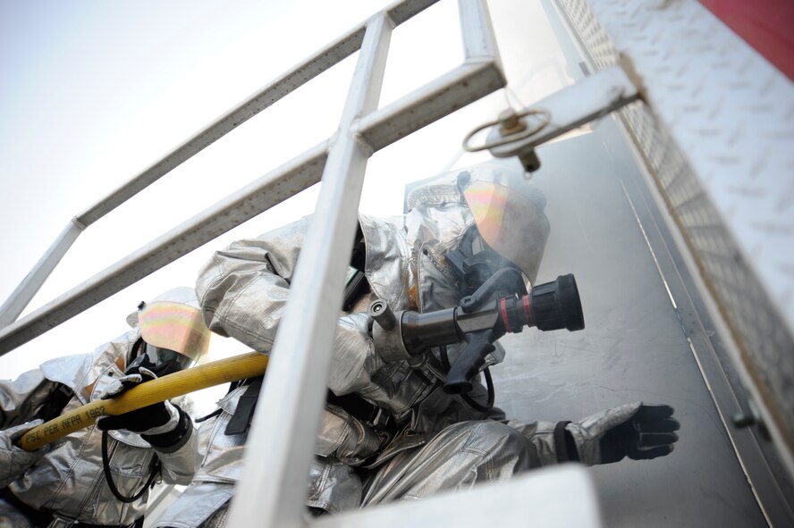 BAGHDAD, Iraq -- Iraqi firefighters enter a mobile training unit to extinguish a fire during a live fire exercise in Baghdad, Iraq on Dec. 24. The exercise is part of an apprentice course where the firefighters will learn basic firefighting skills. (U.S. Air Force photo/Staff Sgt. Paul Villanueva II)