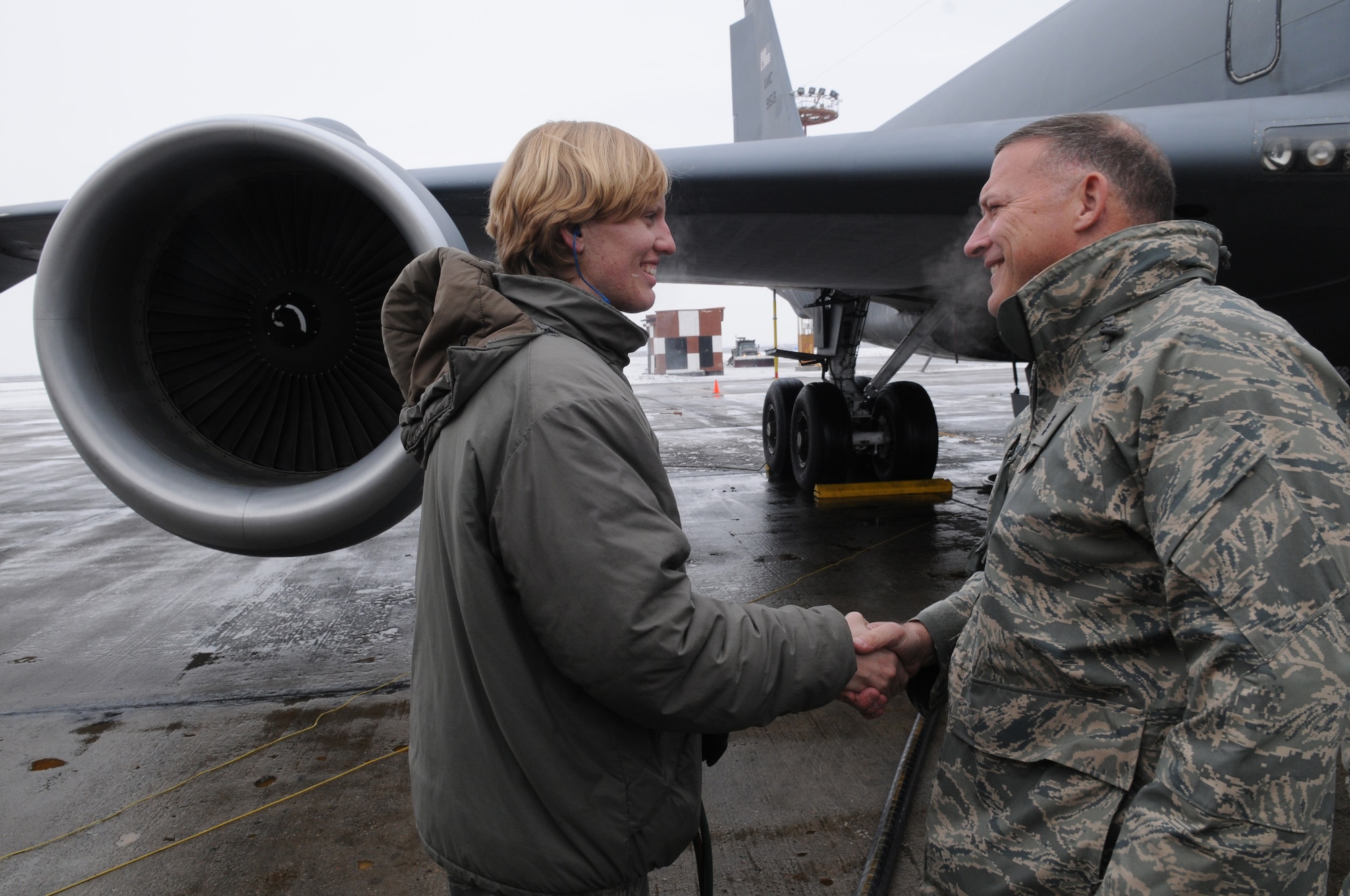 MANAS AIR BASE, KYRGYZSTAN -- Senior Airman Victoria Drefs, a fuels specialist with the 376th Air Expeditionary Wing here, shakes hands with Lt. Gen. Gary North, Air Forces Central Commander, as she is about to reach the 2 million gallon mark for fuel delivered during her deployment.  The Armour S.D. native, deployed to Manas for four months from Aviano Air Base, Italy, is the first and likely only Airman to reach 2 million gallons this rotation. (Air Force photo / Senior Airman Ruth Holcomb)