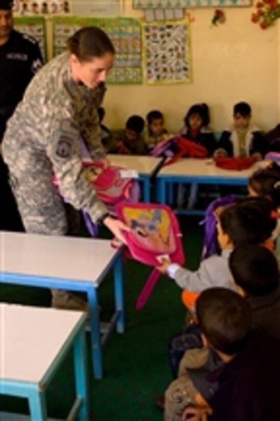 U.S. Army Capt. Charcillea Barrett, commanding officer of the 21st Military Police Company (Airborne) out of Fort Bragg, N.C., distributes backpacks to Iraqi elementary school students in the Al Hayyaniah district of Basra, Iraq, on Dec. 23, 2008.  