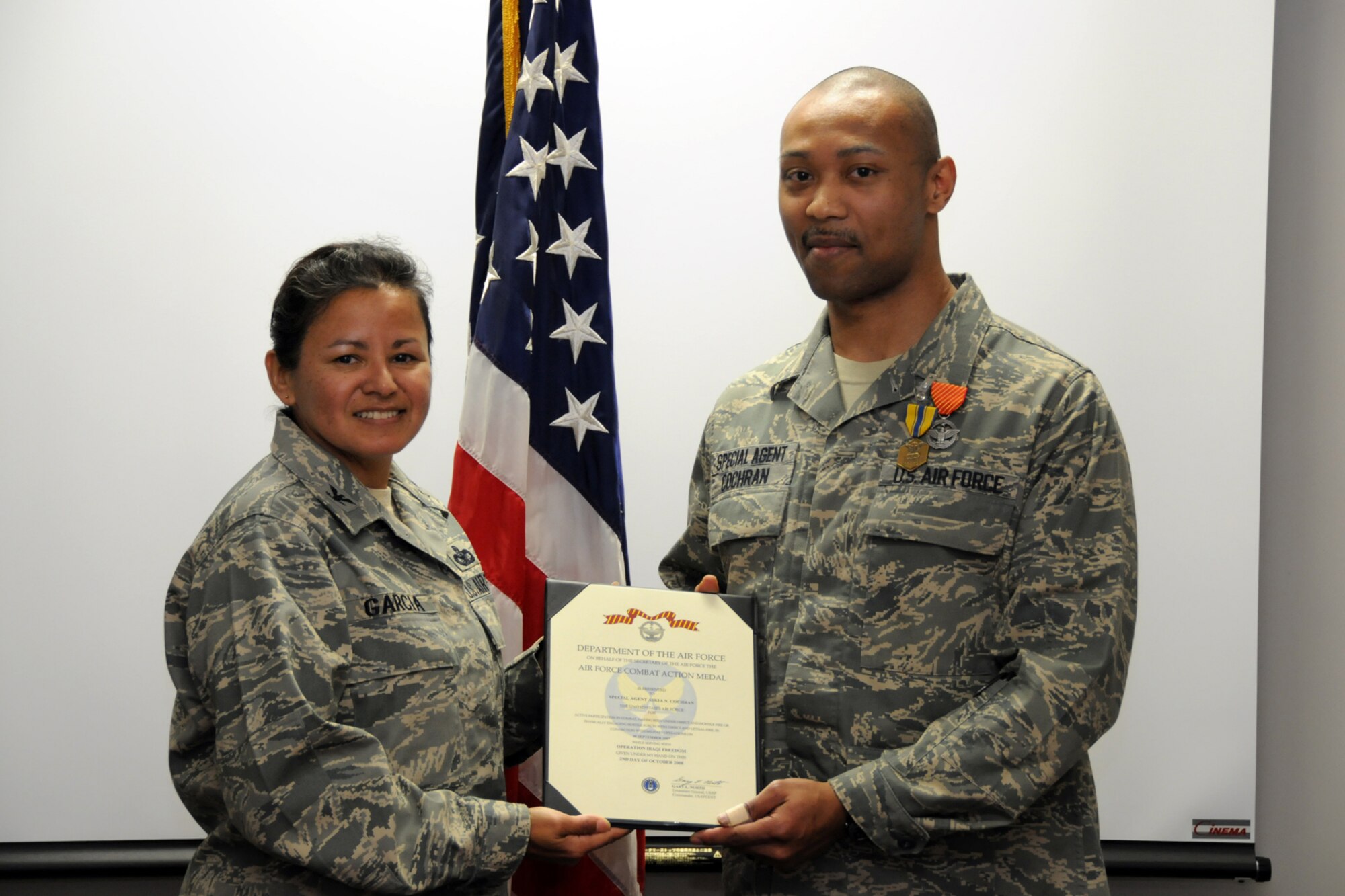 MISAWA AIR BASE, Japan -- Special Agent Askia Cochran, Air Force Office of Special Investigations Detachment 623, receives the Air Force Combat Action Medal Dec. 11, 2008. The medal was presented by Col. Sarah Garcia, AFOSI Region 6 commander, Hickam Air Force Base, Hawaii. (U.S. Air Force photo by Senior Airman Jamal D. Sutter)
