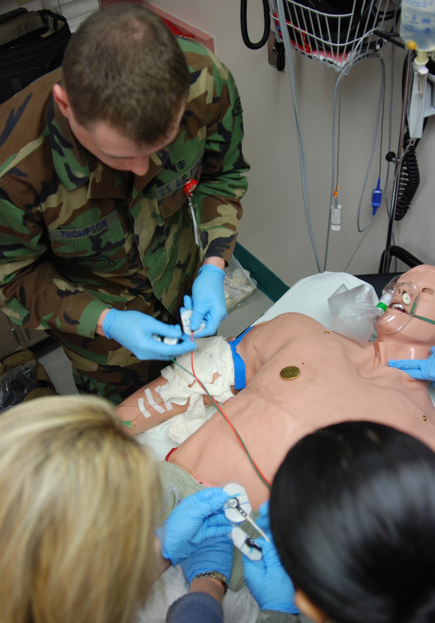 MCCONNELL AIR FORCE BASE, Kan. -- Medics from the base clinic check heart rhythm, vitals and administer drugs to training dummy, METI. The dummy mirrors human responses to intravenous medication, intubation, CPR and treatment provided by the staff during training scenarios. (Photo by Airman 1st Class Jessica Lockoski)