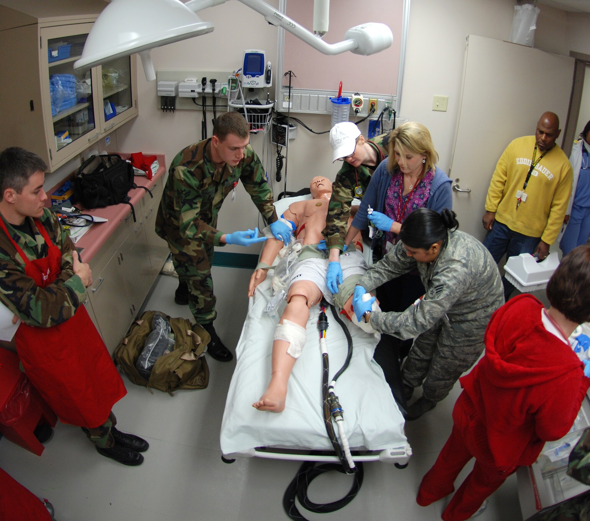 MCCONNELL AIR FORCE BASE, Kan. -- Some 22nd Medical Group medics bustle around METI, a realistic six-foot mannequin, to diagnose and provide medical treatment during a training scenario Dec. 24 at the base’s medical clinic. Trainers stood by programming the dummy to show signs of injuries and ailments which left medics to stabilize the patient. (Photo by Airman 1st Class Jessica Lockoski)