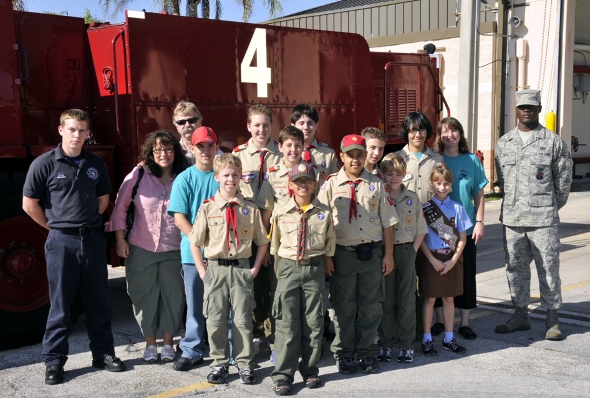 Homestead ARB fighter fighters, Mr. Jeffery Curl, far left, and Airman 1st Class Travis Smith, far right, 482nd Civil Engineering Squadron, pose for a group picture with kids and chaperones from Boy and Girl Scout Troop 599 on Dec. 30.  The Miami Scouts were treated to a tour of the base fire department and air traffic control tower; watched four F-16 fighter jets take-off; and then ate lunch at the Falcons Nest Club.  Homestead ARB offers two tours a month. Groups interested in touring the base should contact the 482nd Fighter Wing Public Affairs Office at least 60 days in advance. The PA office can be reached at (305) 224-7330. (U.S. Air Force photo/Tim Norton)