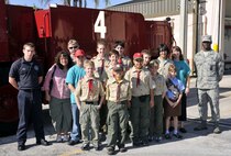 Homestead ARB fighter fighters, Mr. Jeffery Curl, far left, and Airman 1st Class Travis Smith, far right, 482nd Civil Engineering Squadron, pose for a group picture with kids and chaperones from Boy and Girl Scout Troop 599 on Dec. 30.  The Miami Scouts were treated to a tour of the base fire department and air traffic control tower; watched four F-16 fighter jets take-off; and then ate lunch at the Falcons Nest Club.  Homestead ARB offers two tours a month. Groups interested in touring the base should contact the 482nd Fighter Wing Public Affairs Office at least 60 days in advance. The PA office can be reached at (305) 224-7330. (U.S. Air Force photo/Tim Norton)