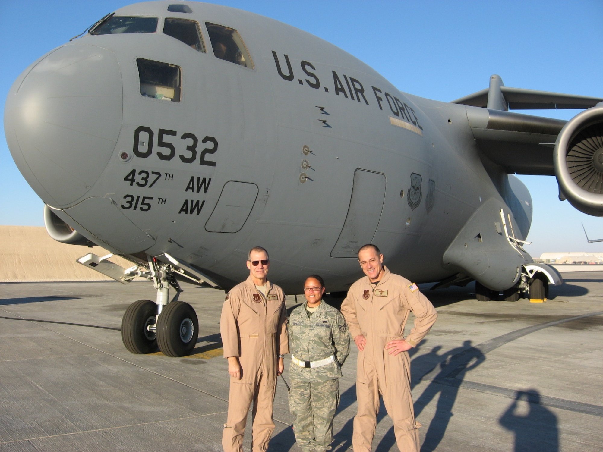 Staff Sgt. Lisa Davis, a crew chief with the 315th Aircraft Maintenance Squadron, poses with Col. Timothy Wrighton, 315th commander, and Chief Master Sgt. Benson Futrell, 315th command chief, Charleston Air Force Base, S.C., on the flight line at Al Udeid, Qatar, on Christmas morning.  SSgt Davis’s civilian job is a school nurse, but instead of pursuing a medical career in the Reserves she chose to become a maintainer for the C-17.   