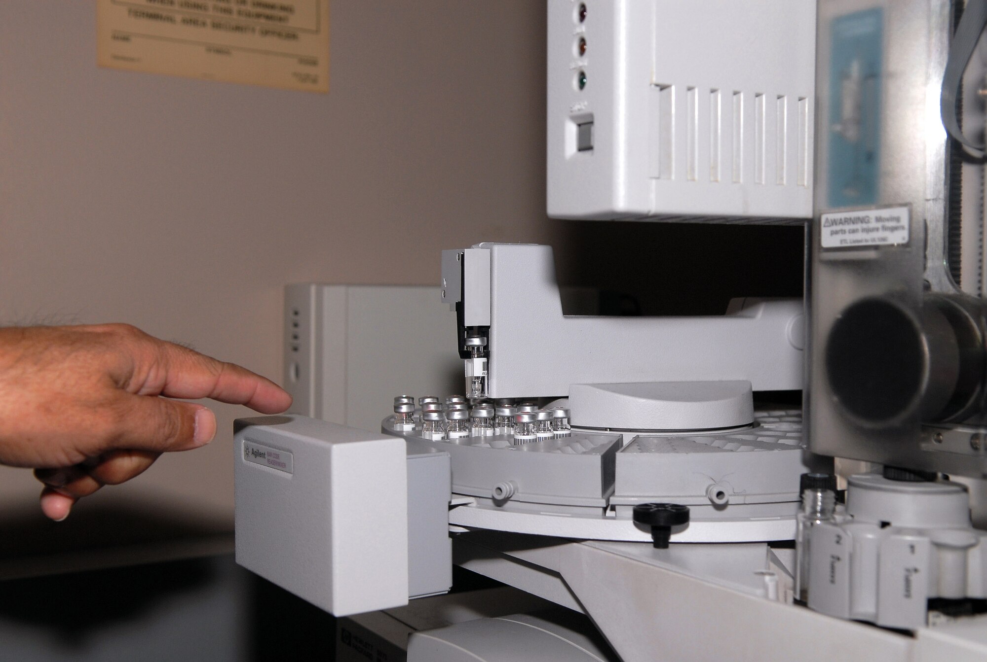A lab specialist at the military drug testing facility at Brooks City-Base, Texas, points out samples prepared for analysis with a gas chromatograph/mass spectrometer. The laboratory's high-tech equipment can find and identify all drugs present. (U.S. Air Force photo/Tech. Sgt. Cheryl Hackley)
