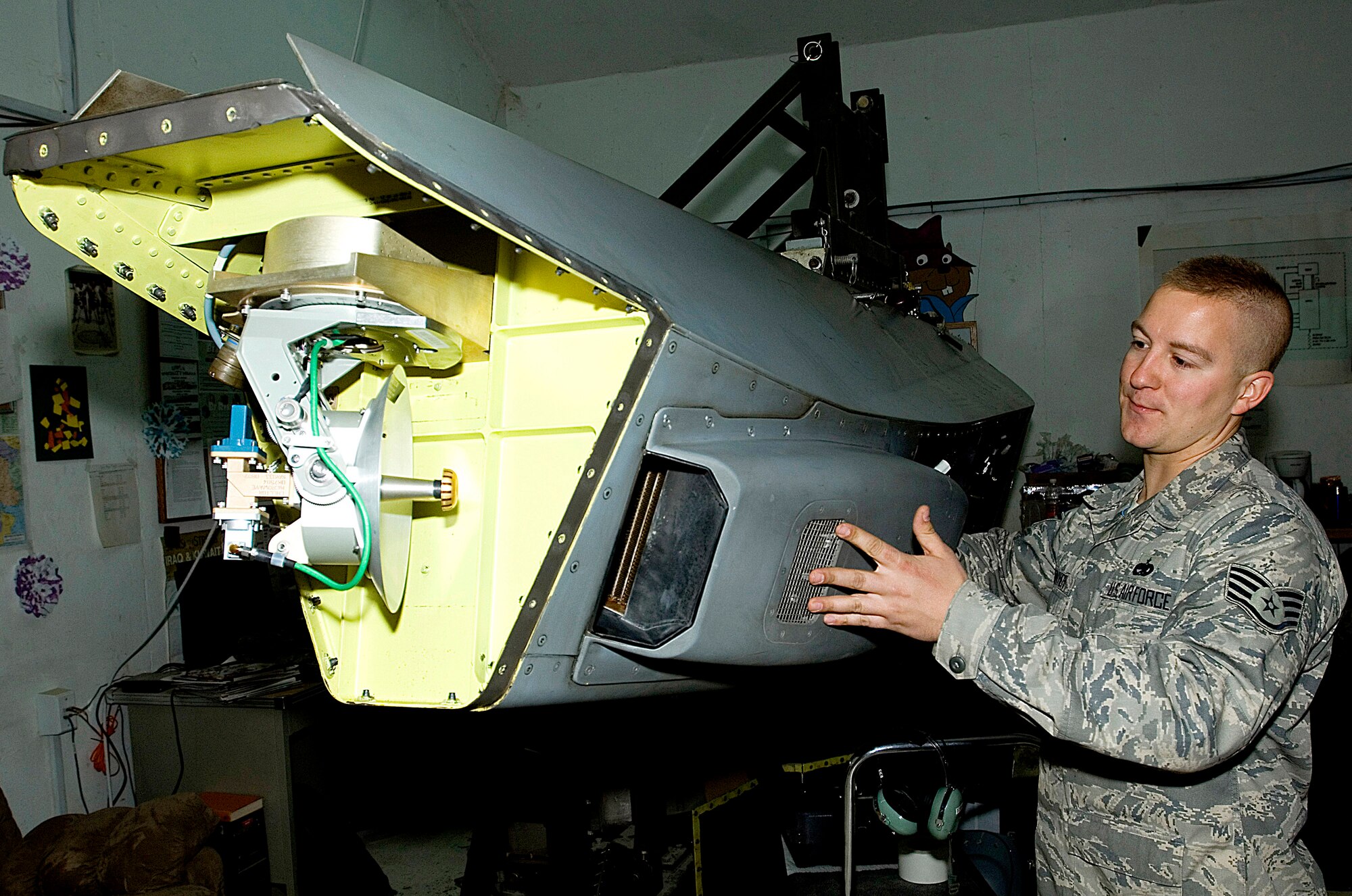 Staff Sgt. George Suonvieri checks out a Theater Airborne Reconnaissance System pod held in place by a giraffe stand Dec. 21 at Joint Base Balad, Iraq. Ground commanders use TARS imagery to achieve their tactical objectives. Sergeant Suonvieri is one of four 332nd Expeditionary Aircraft Maintenance Squadron avionics maintainers responsible for the 332nd Expeditionary Fighter Squadron's TARS pods. Sergeant Suonvieri, a native of Duluth, Minn., is deployed from the Minnesota Air National Guard's 148th Fighter Wing. (U.S. Air Force photo/Tech. Sgt. Erik Gudmundson)