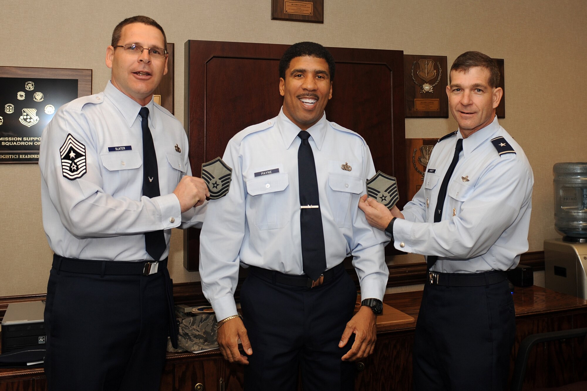LANGLEY AIR FORCE BASE, Va. – Brig. Gen. Mark Barrett, 1st Fighter Wing commander, and Chief Master Sgt. Kevin Slater, 1 FW command chief, present new stripes to Master Sgt. John Payne, 1st Logistics Readiness Squadron, here Dec. 28. General Barrett promoted Sergeant Payne to master sergeant under the Stripes for Exceptional Performers program. (U.S. Air Force photo/Airman 1st Class Gul Crockett)
