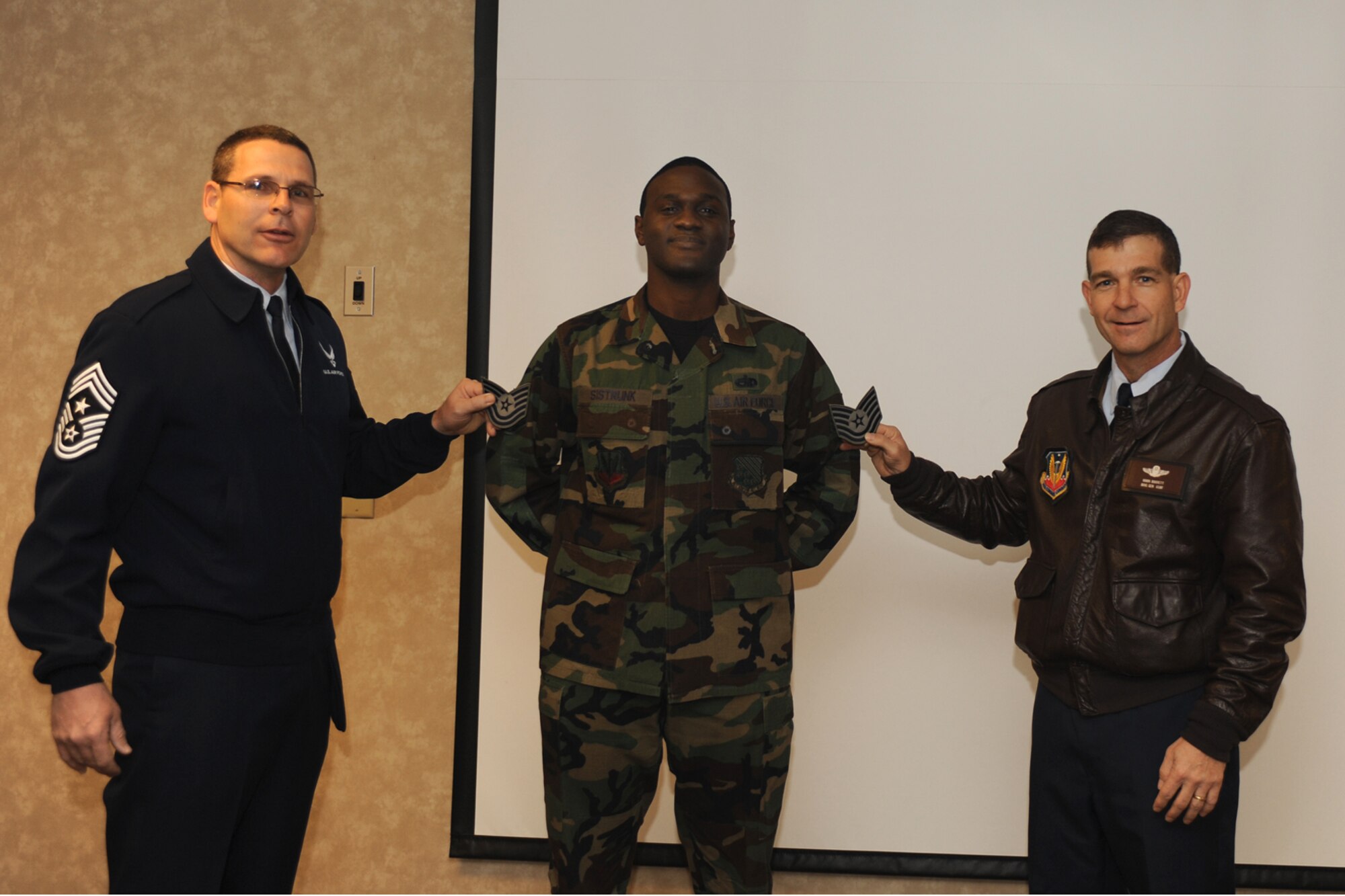LANGLEY AIR FORCE BASE, Va. – Brig. Gen. Mark Barrett, 1st Fighter Wing commander, and Chief Master Sgt. Kevin Slater, 1 FW command chief, present new stripes to Tech. Sgt. Gabe Sistrunk, 1st Operational Squadron, here Dec. 28. General Barrett promoted Sergeant Sistrunk to technical sergeant under the Stripes for Exceptional Performers program. (U.S. Air Force photo/Airman 1st Class Gul Crockett)

