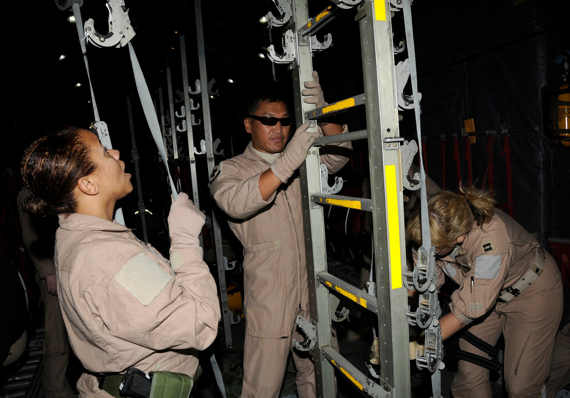 Staff Sgt. Tyronda Summers, an aeromedical evacuation technician and Captains Tim Bougie and Bonnie Tallarita, both flight nurses assigned to the 379th Expeditionary Aeromedical Evacuation Squadron, attach C-130 litter stanchions and straps as part of setting up for an air evacuation of injured personnel Dec. 29, 2008, at an undisclosed air base in Southwest Asia. These EAES members are responsible for evacuating injured personnel from the area of responsibility and providing medical assistance until they arrive at a medical facility. Sergeant Summers, a native of Sioux City, Iowa, is deployed from Ramstein Air Base, Germany. Captain Bougie, a native of Minneapolis, Minn., is deployed from the Minnesota Air National Guard. Captain Tallarita, a native of New Richmond, Wis., is also deployed from the Minnesota Air National Guard. All are assigned to the 379th Expeditionary Aeromedical Evacuation Squadron and deployed in support of Operations Iraqi and Enduring Freedom and Joint Task Force-Horn of Africa. (U.S. Air Force photo by Staff Sgt. Darnell T. Cannady/Released)