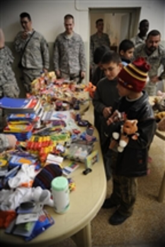 Orphaned Iraqi boys at the Orphanage of Saint Joseph in Al Qosh, Iraq, pick from an assortment of toys, food and school supplies brought to them by U.S. Army soldiers of Ironhawk Troop, 3rd Squadron, 3rd Armored Cavalry Regiment on Dec. 23, 2008.  