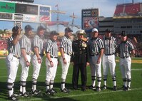 Brig. Gen. Thomas Milstead, Marine Corps Recruiting Command commanding general, poses for pictures with the officiating crew of the Outback Bowl Jan. 1 at Raymond James Stadium in Tampa, Fl.