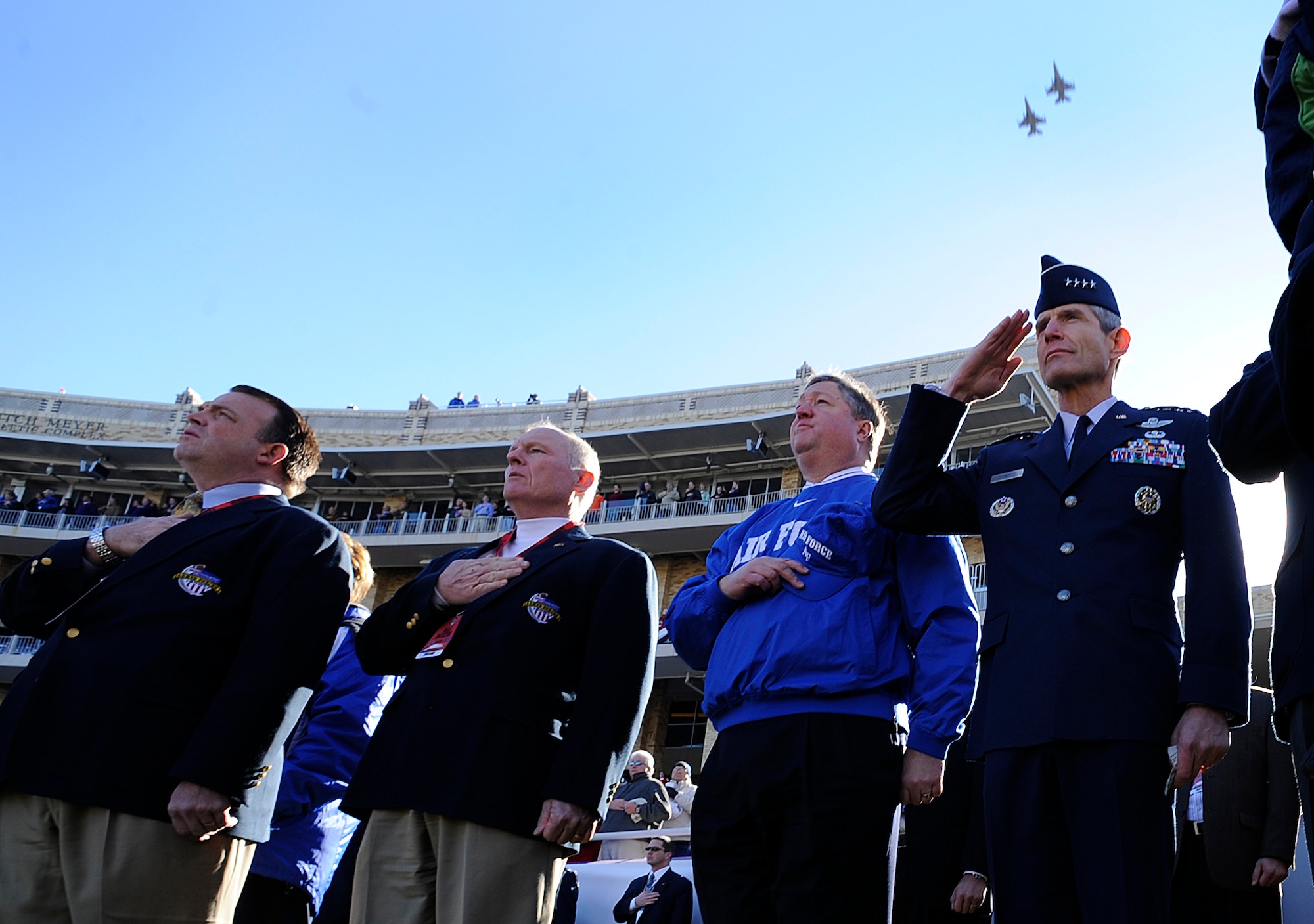 Secretary of the Air Force Micheal B. Donley (center) and Air Force Chief of Staff Gen. Norton A. Schwartz (right) salute during the national anthem while F-16 Fighting Falcons from the 301st Fighter Wing perform a fly-over before the Bell Helicopter Armed Forces Bowl game between the U.S. Air Force Academy and the University of Houston on Dec. 31 at Fort Worth, Texas. (U.S. Air Force photo/Staff Sgt. Bennie J. Davis III)