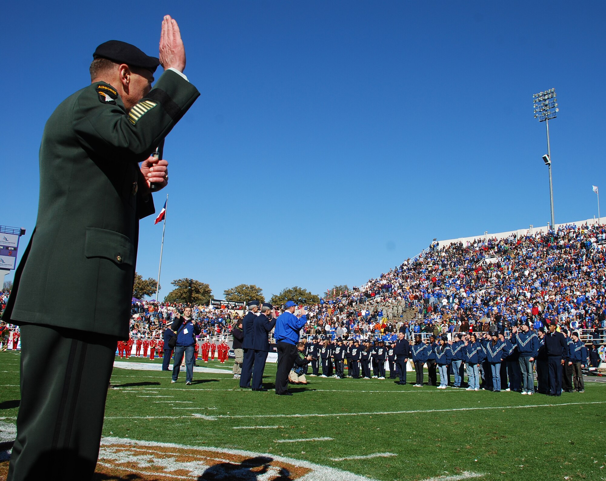General David H. Petraeus, U.S. Central Command commander, leads a mass enlistment for new enlistees of all the armed services during the Armed Forces Bowl halftime. Gen. Patraeus was also named the 2008 Great American Patriot Award recipient. (U.S. Air Force Photo/Tech. Sgt. Julie Briden-Garcia)