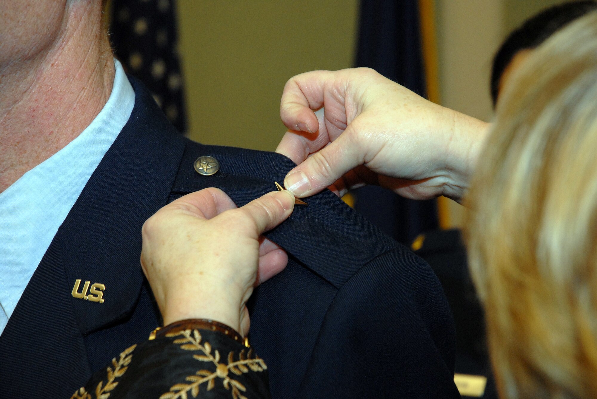 Julie Foster, wife of newly promoted Brig. Gen. Charles E. "Chuck" Foster, pins on one of the new general's stars at a promotion ceremony held Dec. 18 before a packed house at Kulis Air National Guard Base. As a commander's spouse, Julie plays an important role in the wing's family support programs. Alaska Air National Guard photo by 2nd Lt. John Callahan