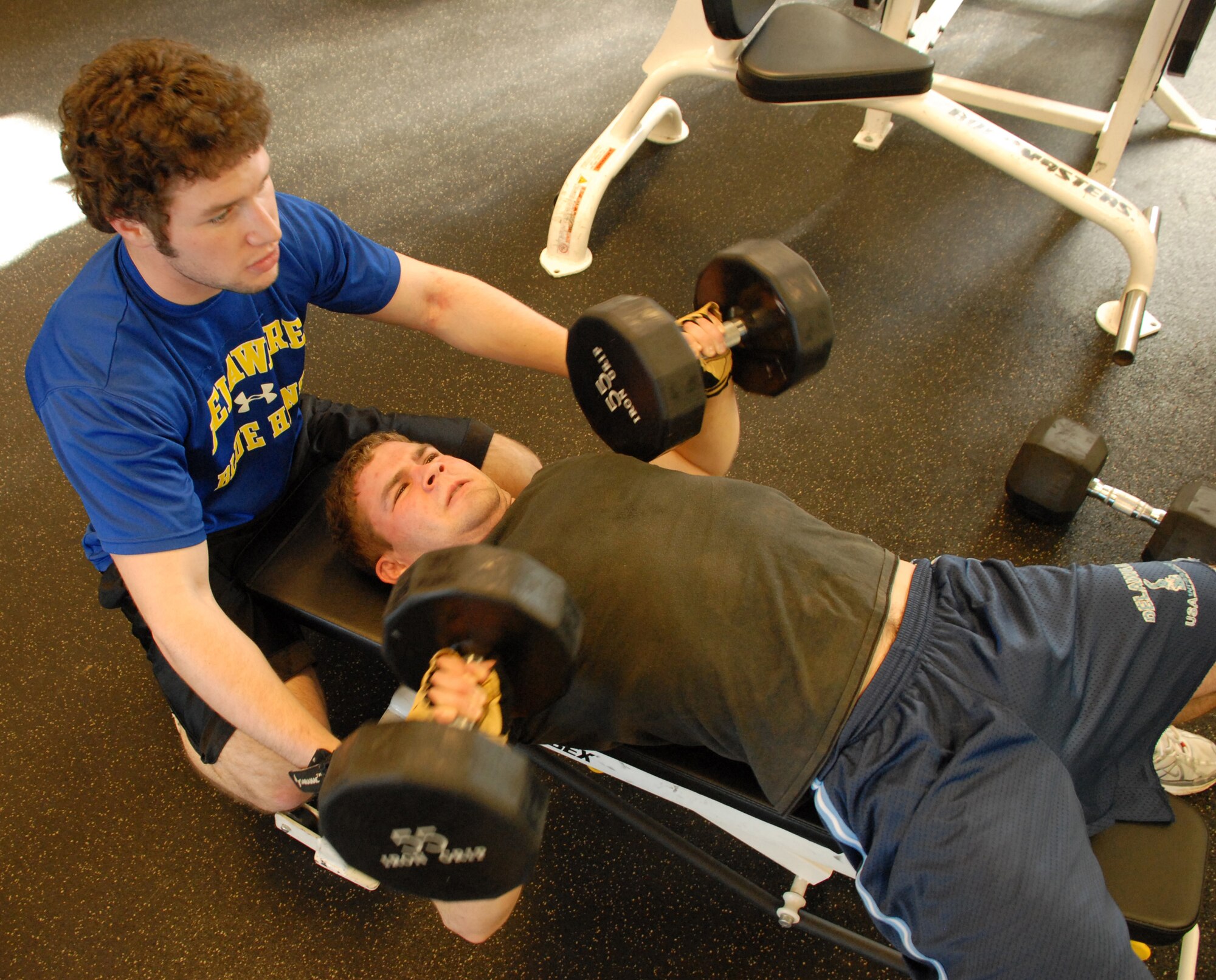 DOVER AIR FORCE BASE, Del. ? (Left to right) Jimmy Walters spots his brother, John Walters, as he presses 55-pound dumbbells on the bench. Both brothers said they will strive towards better grades in school, eat healthier and work out to stay fit. (U.S. Air Force photo/ Airman 1st Class Shen-Chia Chu)