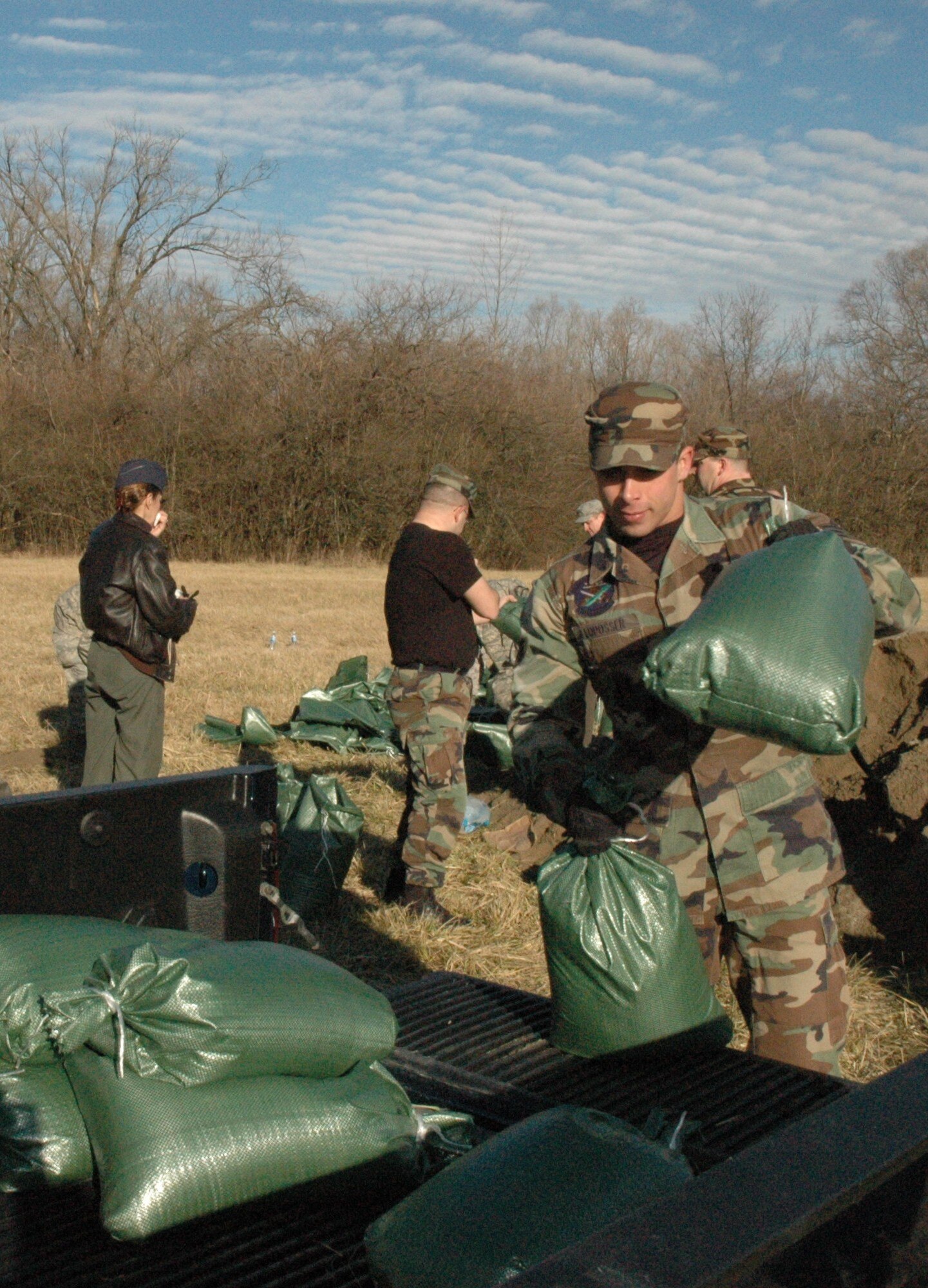 Senior Airman Caleb Loposser, 88th Security Forces Squadron, loads filled sandbags into a pickup truck for transport to other areas of the training compound.  