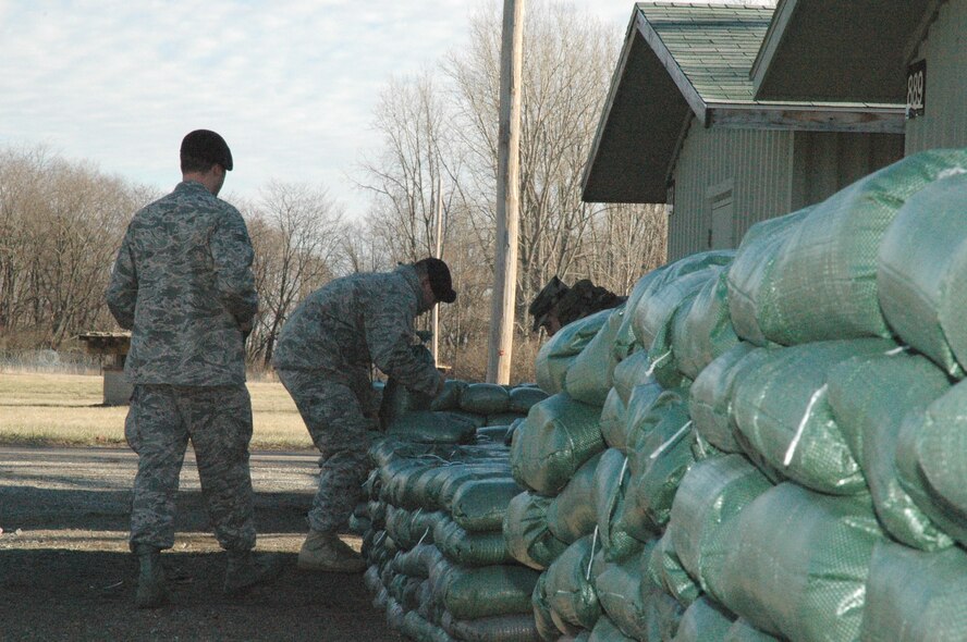 88th Air Base Wing Airmen carefully stack filled sandbags to protect the doorways into structures in the Warfighter Training Center at Wright-Patterson AFB, Ohio.