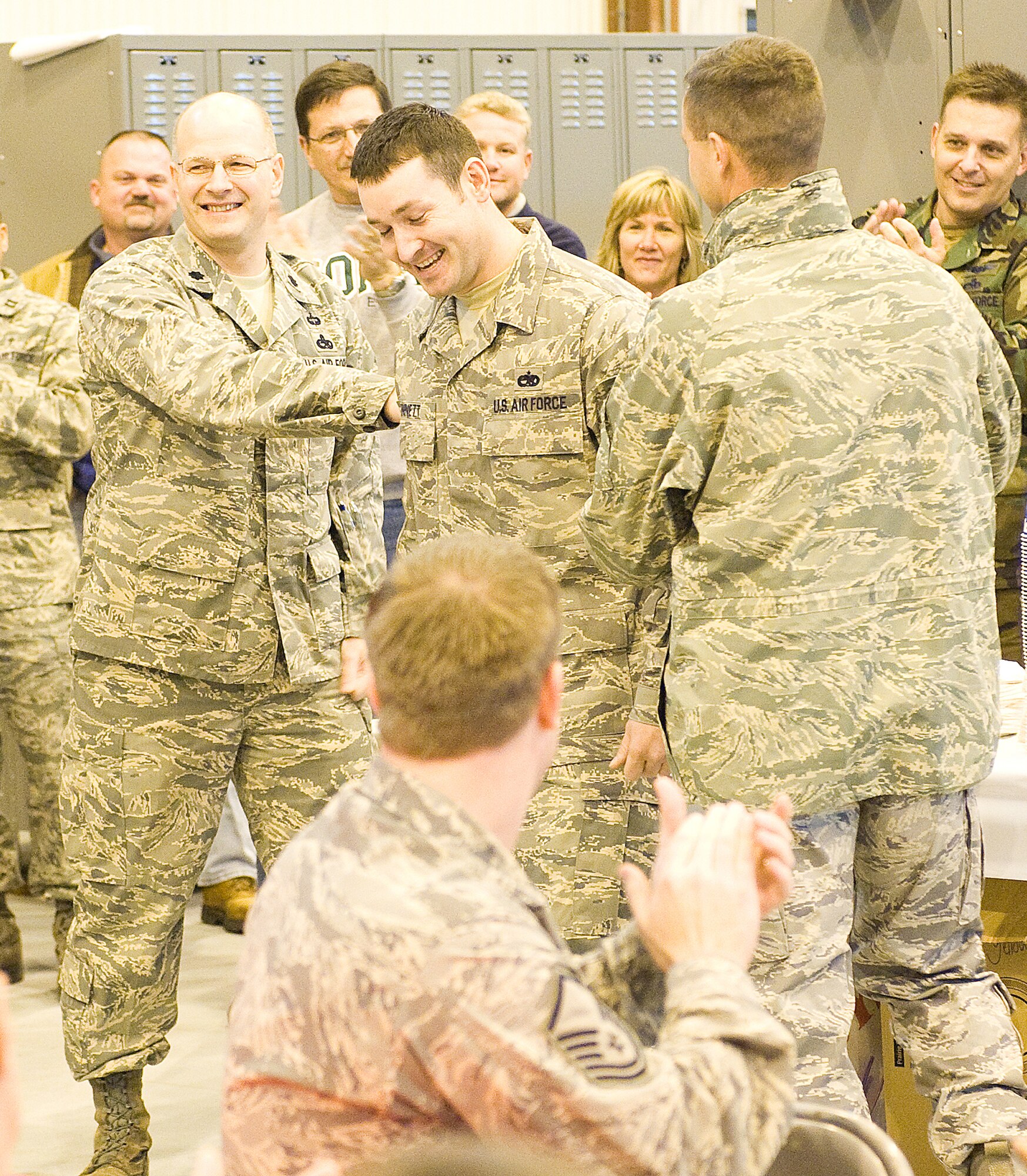 DOVER AIR FORCE BASE, Del. ? Staff Sgt. Bryan Bennett, 736th Aircraft Maintenance Squadron, has his stripes tacked on by (Left) Lt. Col. Raymond Briggs, 736th AMXS commander, and Col. Steven Harrison, 436th Airlift Wing commander, during a Stripes for Exceptional Performers promotion to the rank of technical sergeant Dec. 24. (U.S. Air Force photo/Tom Randle)
