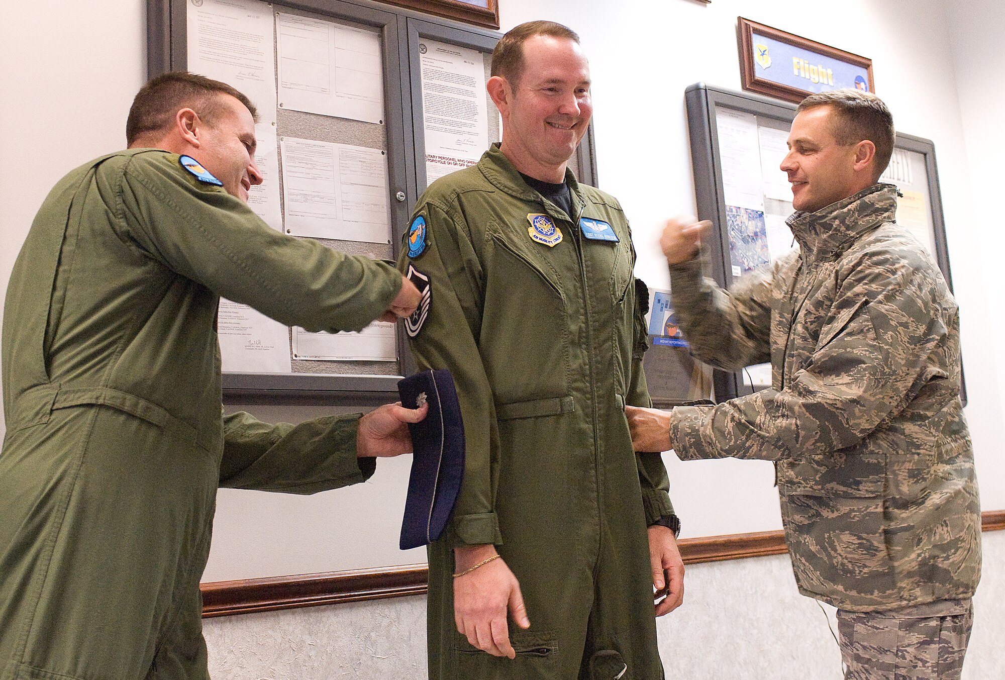 DOVER AIR FORCE BASE, Del. ? Tech. Sgt. Steve Dirksen, 9th Airlift Squadron, has his stripes tacked on by (Left) Lt. Col. Kenneth Bibb, 9th AS commander, and Col. Steven Harrison, 436th Airlift Wing commander, during a Stripes for Exceptional Performers Promotion to the rank of master sergeant Dec. 24. (U.S. Air Force photo/Tom Randle)