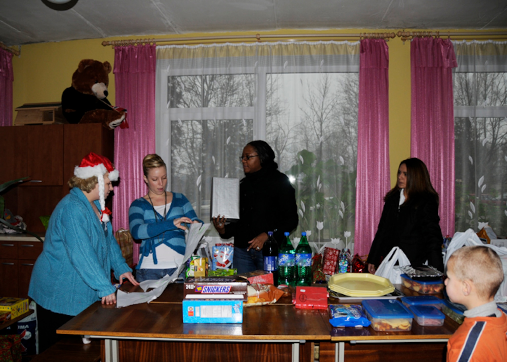 Master Sgt. Margaret Williams, Senior Airman Hannah Parker, Tech. Sgt. Kenya Meyers and Airman 1st Class Samantha Melendez, 493rd Expeditionary Fighter Squadron, hand out presents at the Kelme District Vijurkai Children’s Home Dec. 19 in Lithuania. More than 100 Airmen supporting the NATO Baltic Air Policing mission in Siauliai, Lithuania threw a holiday party for the children to spread their generosity and holiday cheer.