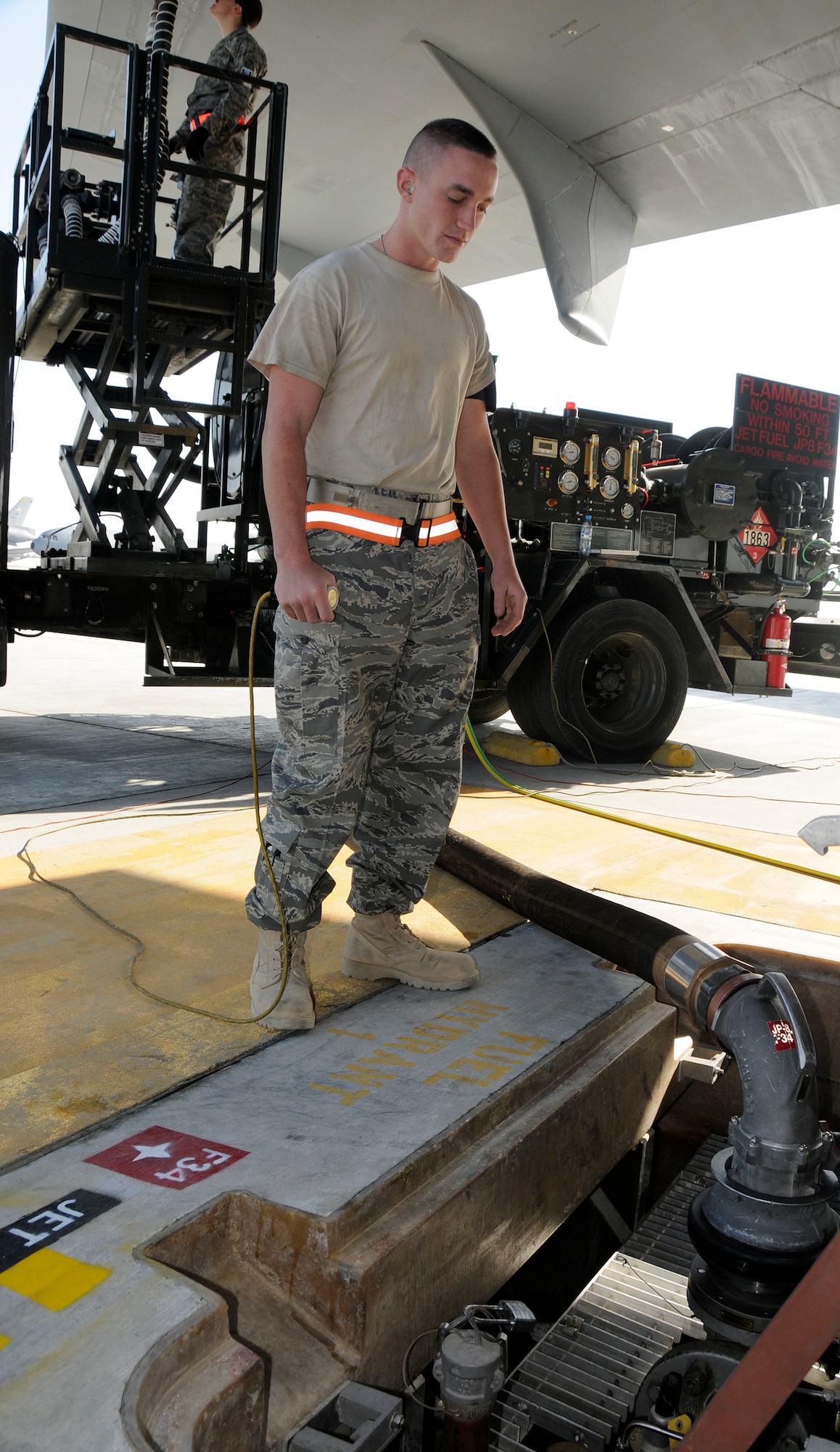 SOUTHWEST ASIA -- Airman 1st Class Stuart Brennan from the 380th Expeditionary Logistics Readiness Squadron checks his gauges while he uses a "dead man" to refuel a KC-10 Extender here. This is a device that the fuels Airmen use to ensure there is a constant flow maintained during refueling. Airman Brennan has to grip the "dead man" and release it within 90 seconds continually throughout the refueling process. The average fuel transfer rate is 600 gallons per minute. Airman Brennan is deployed from the 20th LRS, Shaw Air Force Base, S.C., his hometown is Westerly, R.I. (U.S. Air Force photo/Tech. Sgt. Christopher A. Campbell) (released)