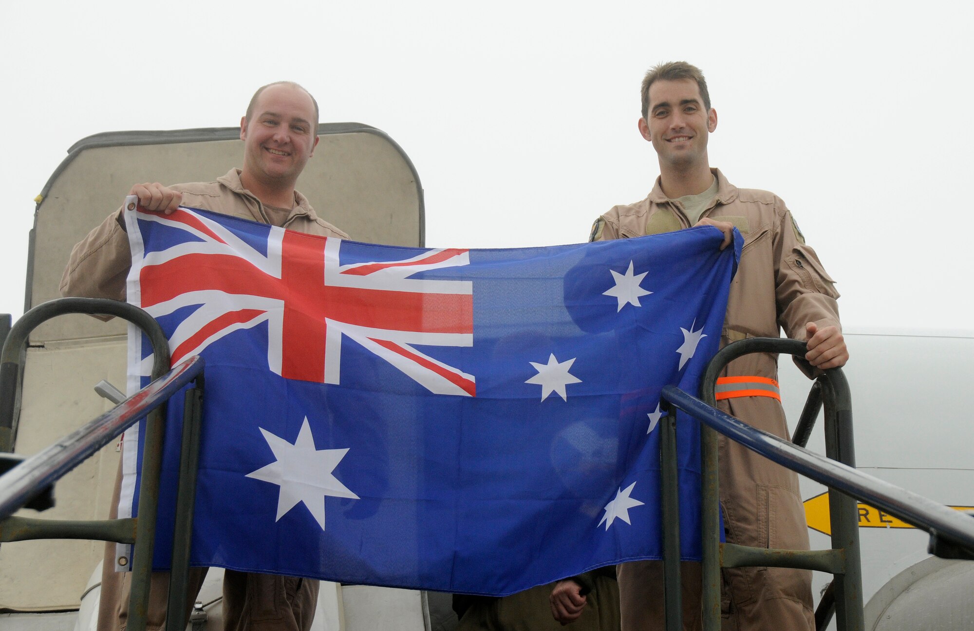 SOUTHWEST ASIA -- Flight Lieutenants Nathan Yabsley and Troy Roempke with the 965th Expeditionary Airborne Air Control Squadron proudly display the Australian flag here Dec. 24. They were preparing to fly their final mission with the 380th Air Expeditionary Wing before heading home to Australia. They have been with the 965th out of Tinker Air Force Base, Okla. for three years with the last four months in a deployed location gaining valuable frontline experience. While deployed with the 965th Flight Lieutenants Yablsey and Roempke have flown 20 missions in the area of responsibility in support of Operations Iraqi and Enduring Freedom. (U.S. Air Force photo/Tech. Sgt. Christopher A. Campbell)(released)