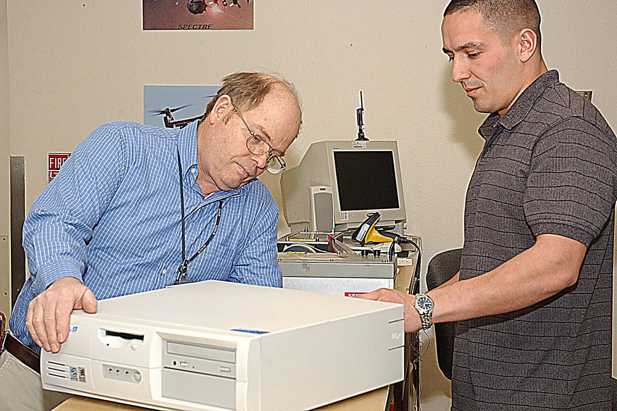 CANNON AIR FORCE BASE, N.M. --Terry Splawn, the Precision Measurement Equipment Laboratory  site manager, and Bryan Kosier, a Support Services Technician, inspect a computer returned to the 27 Special Operations Component Maintenance Squadron PMEL laboratory on Jan. 30. PMEL handles all precision measurement and equipment calibration for Cannon Air Force Base. (Air Force photo by Beth Merchant)

                               