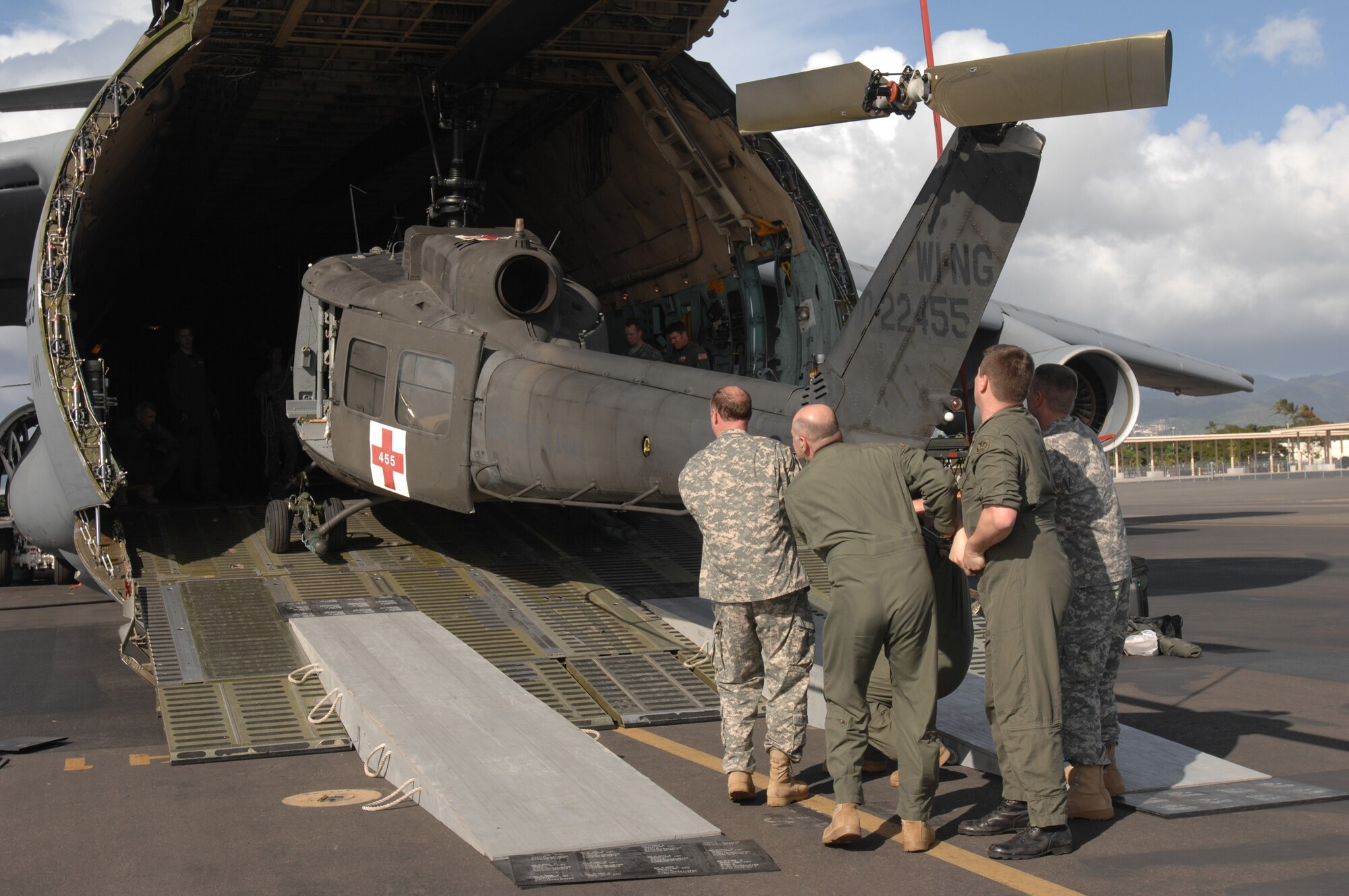 U.S. Army Soldiers with the 832nd Medical Company (Air Ambulance), Westbend, Wis., unload a UH-1 Huey helicopter at Hickam Air Force Base, Hawaii, Jan. 29 during exercise Pacific Lifeline. The exercise is intended to test the military's ability to rapidly deploy a trained and equipped team anywhere in the Pacific in response to a humanitarian assistance mission or disaster scenario. (U.S. Air Force photo /Staff Sgt. Samara M. Scott)