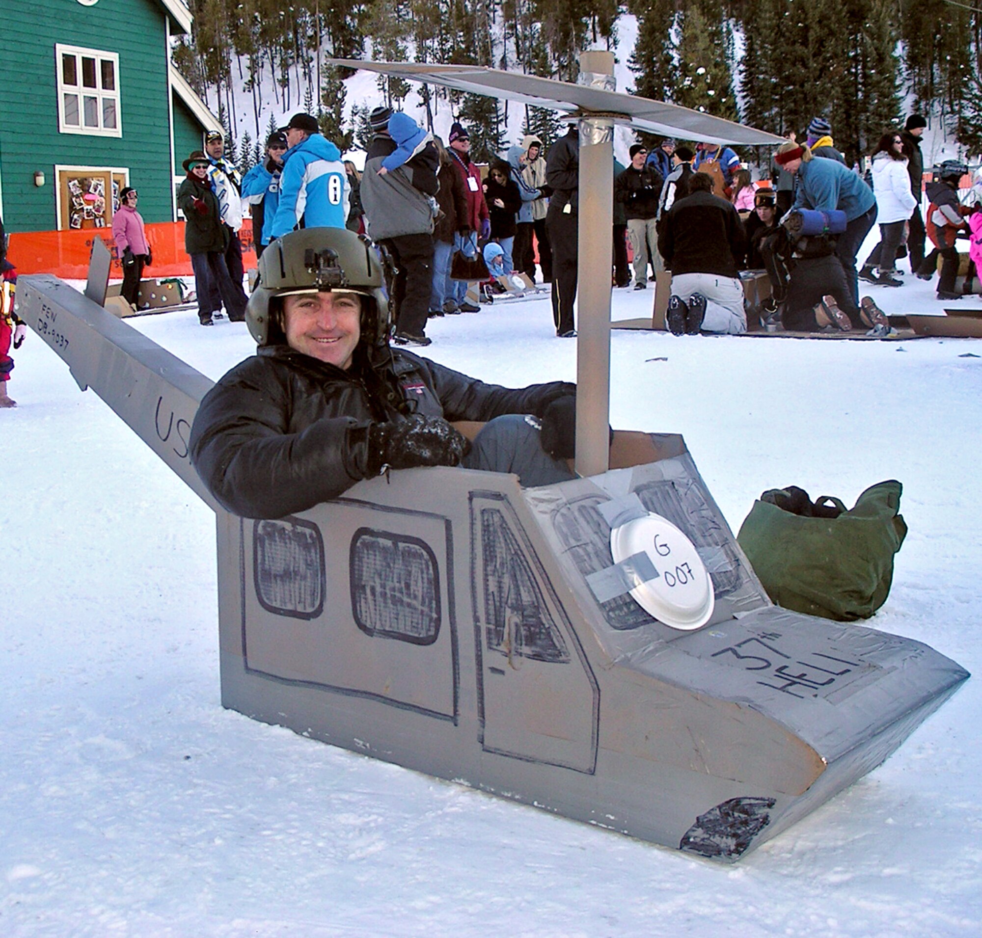 Lt. Col. Lawrence McLaughlin, 37th Helicopter Squadron commander, sits in a cardboard helicopter during an event at SnoFest. This year was the 18th SnoFest with more than 3,400 service members and their families attending (U.S. Air Force photo).