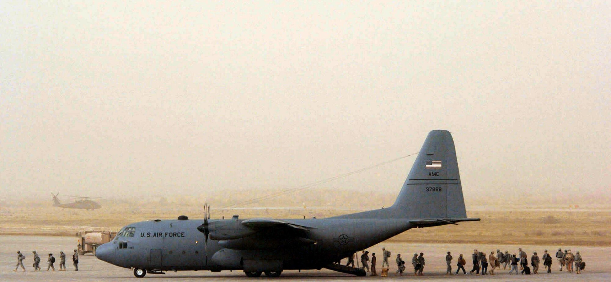 Personnel supporting Operation Iraqi Freedom load onto a C-130 Hercules during a dust storm Jan. 30 at Sather Air Base, Iraq. Sather AB is located on the west side of Baghdad International Airport and base Airmen move 6,200 passengers weekly and more than 1,700 tons of cargo weekly. (U.S. Air Force photo/Tech. Sgt. Jeffrey Allen) 