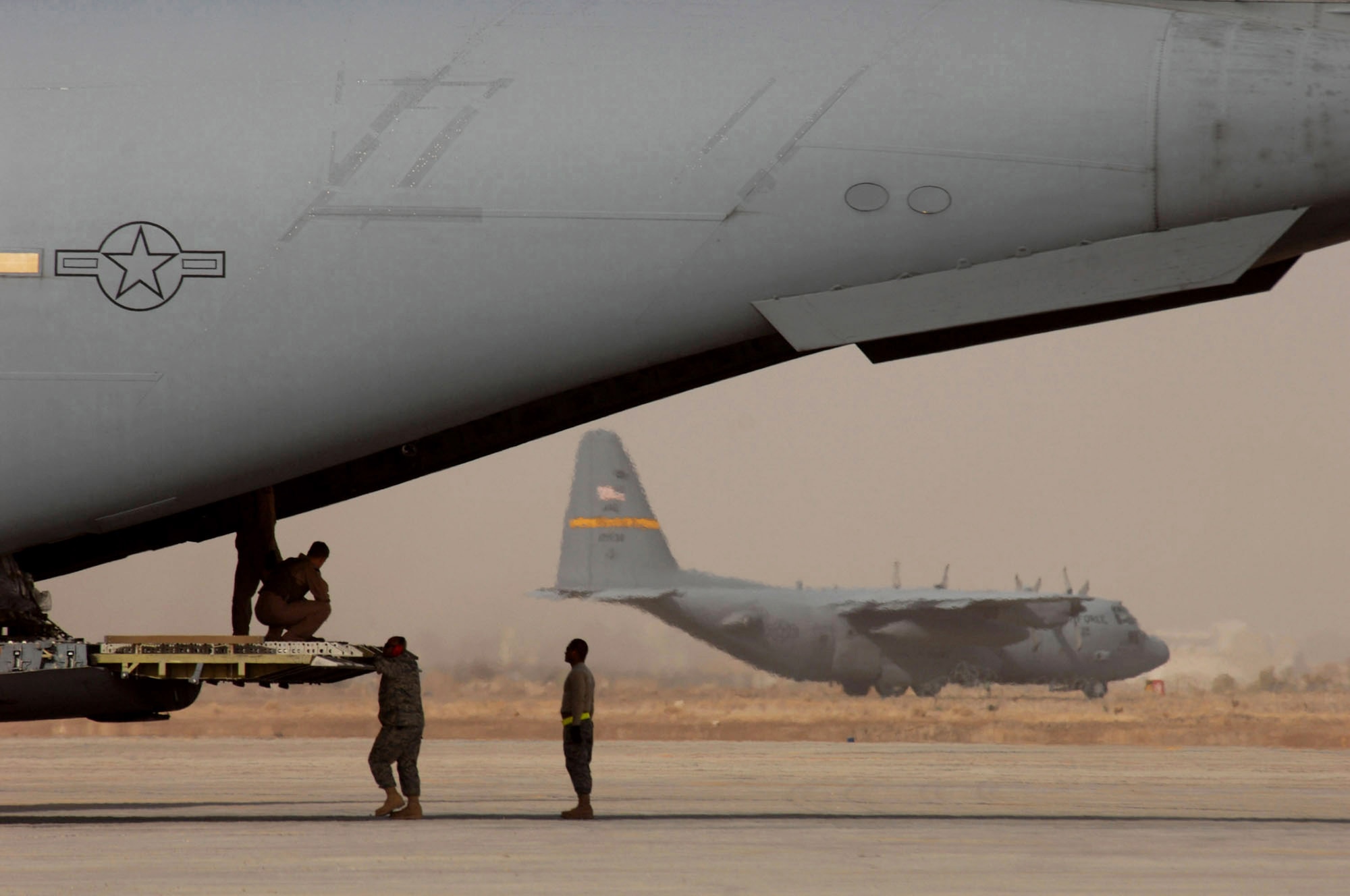 Airmen wait for a pallet of equipment to load on a C-17 Globemaster III Jan. 30 at Sather Air Base, Iraq. Sather AB is located on the west side of Baghdad International Airport and base Airmen move 6,200 passengers weekly and more than 1,700 tons of cargo weekly. (U.S. Air Force photo/Tech. Sgt. Jeffrey Allen) 
