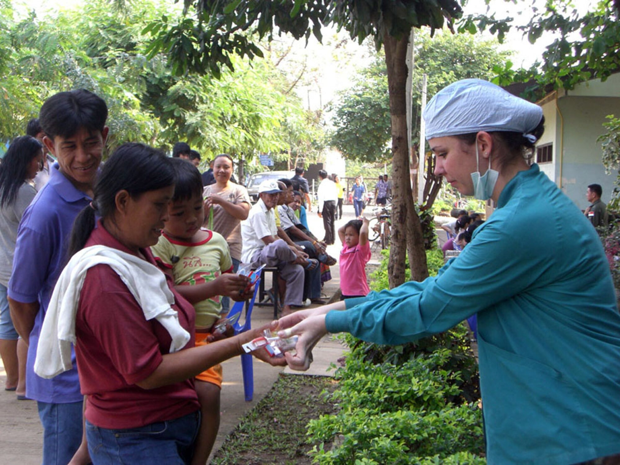 Senior Airman Grace Peon gives a Thai family a toothbrushing kit at Ban Don Phawa School Jan. 30 in a rural village outside of Korat, Thailand. Airman Peon, a dental technician from the 18th Dental Squadron in Kadena Air Base, Japan, is part of a Pacific Air Forces medical team that provided medical and dental care to local residents of the rural village outside of Korat. (U.S. Air Force photo/Capt. Renee Lee) 
