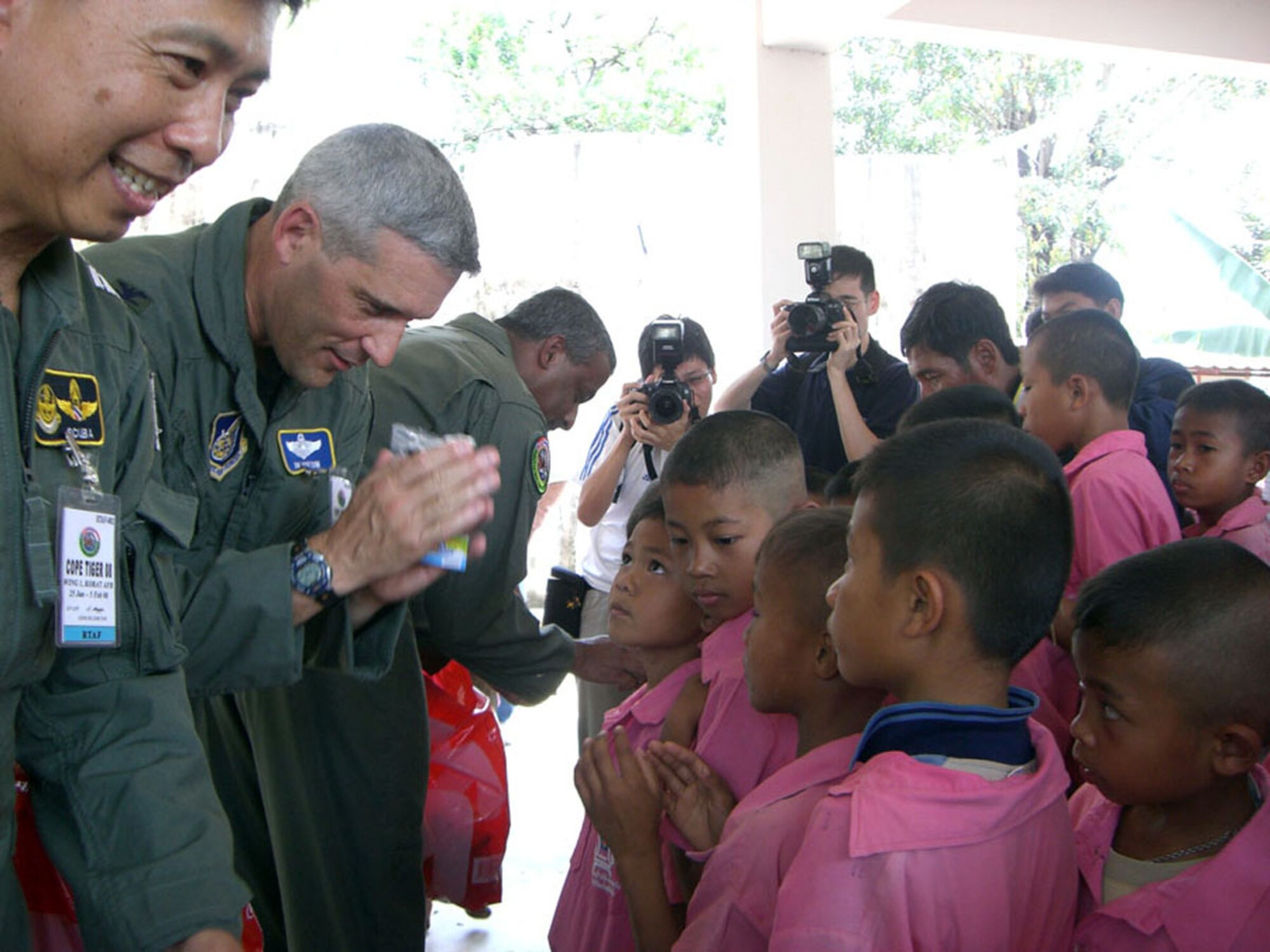 Col. James Horton (center) returns a "wai" to young Thai students of Ban Don Phawa School Jan. 30 in a rural village outside of Korat, Thailand. The colonel, along with Group Captain Suksom Sukasam, the Royal Thai air force deputy exercise director (left) and Col. Anil Sankar, the Republic of Singapore air force exercise director, presented equipment donations to the school as a part of a humanitarian mission. Colone Horton is the 13th Air Expeditionary Wing commander for Exercise Cope Tiger 2008. (U.S. Air Force photo/Capt. Renee Lee) 

