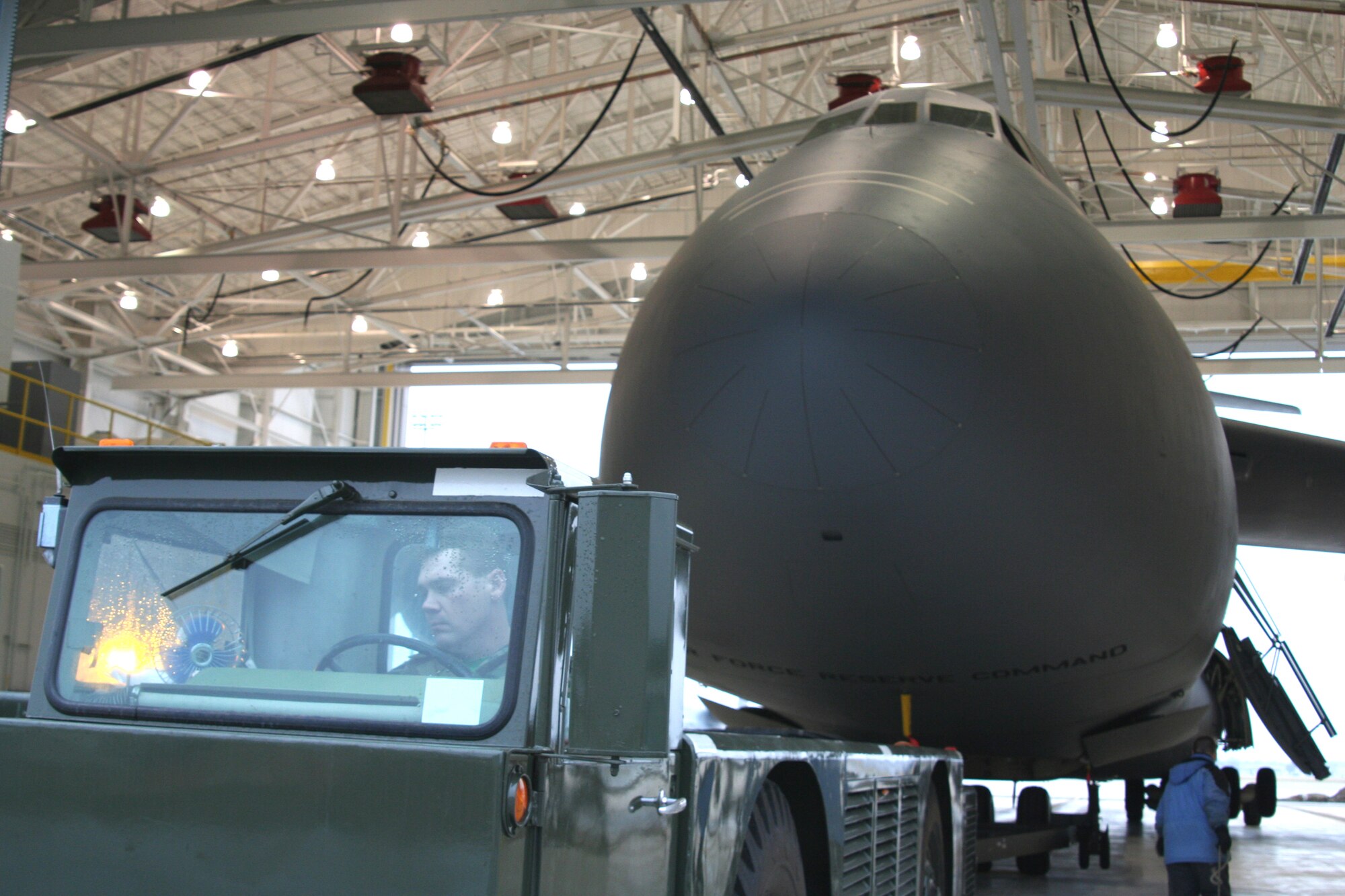 WRIGHT-PATTERSON AFB, Ohio - Tech. Sgt. Mike Haggitt, 445th Aircraft Maintenance Squadron, tows a C-5 into the 445th Airlift Wing's shiny new Multi-Purpose Hangar for the first time Jan. 29, 2008.  The new hangar is designed for unscheduled C-5 maintenance including full wash, spot paint capability, non-destructive inspection of components on the aircraft (x-ray), and aircraft jacking.  The new hangar is part of a $65 million construction project to accomodate the C-5 Galaxy aircraft, the largest aircraft in the Air Force inventory.  (U.S. Air Force Photo/Laura Darden)