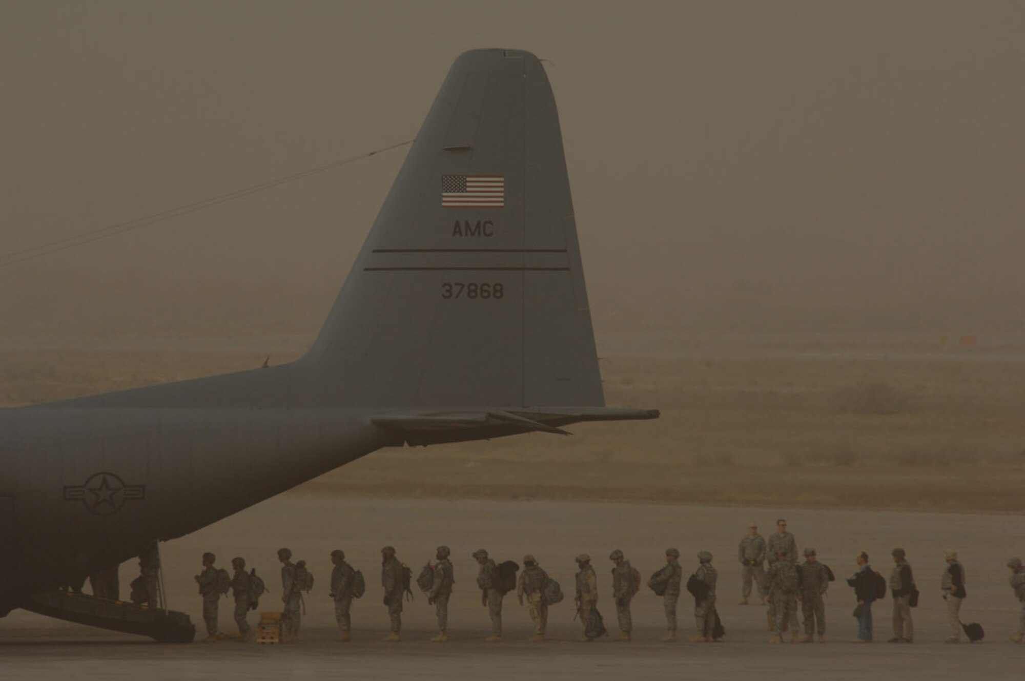 Personnel supporting Operation Iraqi Freedom load on to a C-130 Hercules during a dust storm at Sather Air Base, Iraq, on January 30, 2008. Sather AB is located on the west side of Baghdad International Airport and is the largest mover of passengers in Iraq, averaging 6,200 passengers weekly and the second largest mover of cargo in Iraq, averaging more than 1,700 tons weekly. (U.S. Air Force photo by Tech. Sgt. Jeffrey Allen)

