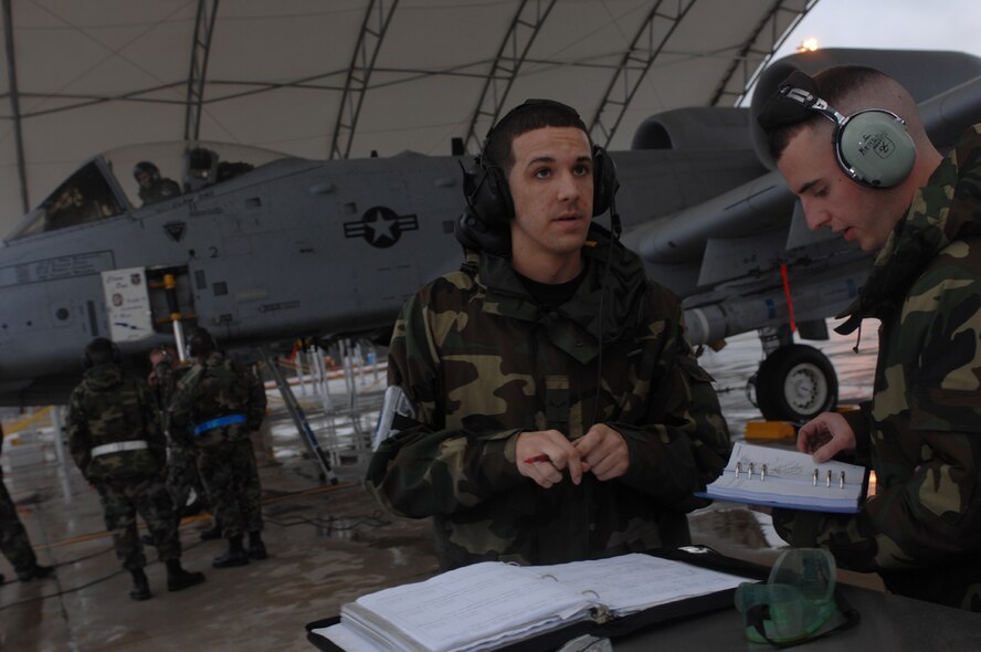 MOODY AIR FORCE BASE, Ga. – Airman 1st Class Douglas Timmons and Staff Sgt. Charles Kendall, 23rd Aircraft Maintenance Squadron electrical-environmental journeymen, review technical orders during a preflight maintenance response Feb 1. For safety reasons, the A-10C Thunderbolt II required more troubleshooting and this pilot aborted his training mission.  (U.S. Air Force photo by Senior Airman Angelita Lawrence)
