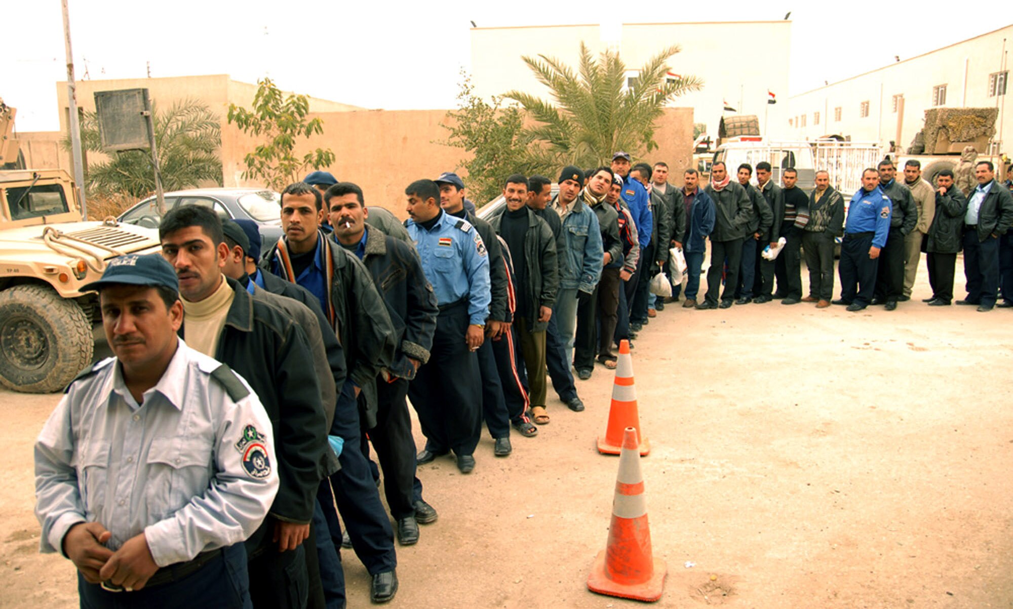 Hy al Amil Iraqi police officers wait in line Jan. 30 at the Joint Security Station Black Lion in Baghdad, Iraq, to receive their monthly pay.  One hundred ninety-three officers went through a security search for verification and identification prior to being paid. U.S. expeditionary security forces members helped with the process for the third month in a row. (U.S. Army photo/Sgt. Daniel Blottenberger) 